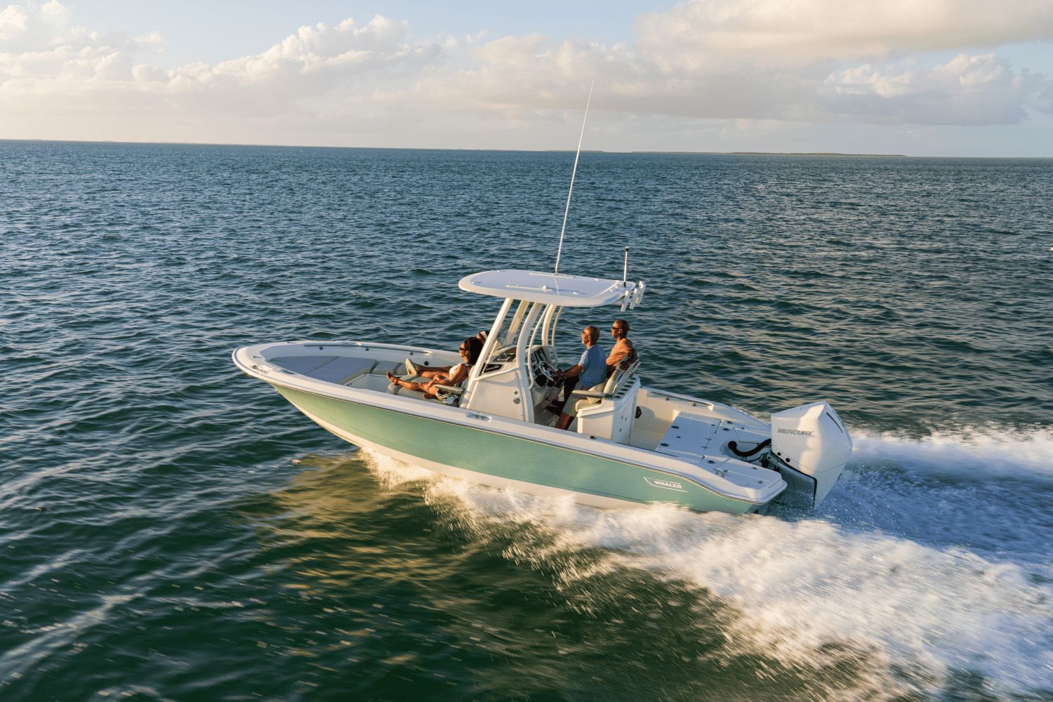 A Boston Whaler 25DA boat speeds across the sea in sunny weather.
