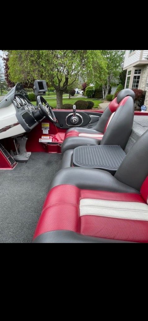 The image shows the cockpit of a 2009 Ranger Z520 Comanche boat with red and gray seats.