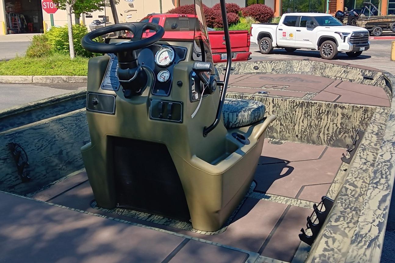 2026 Tracker Grizzly 1860 CC boat interior with steering console and camouflage seating.