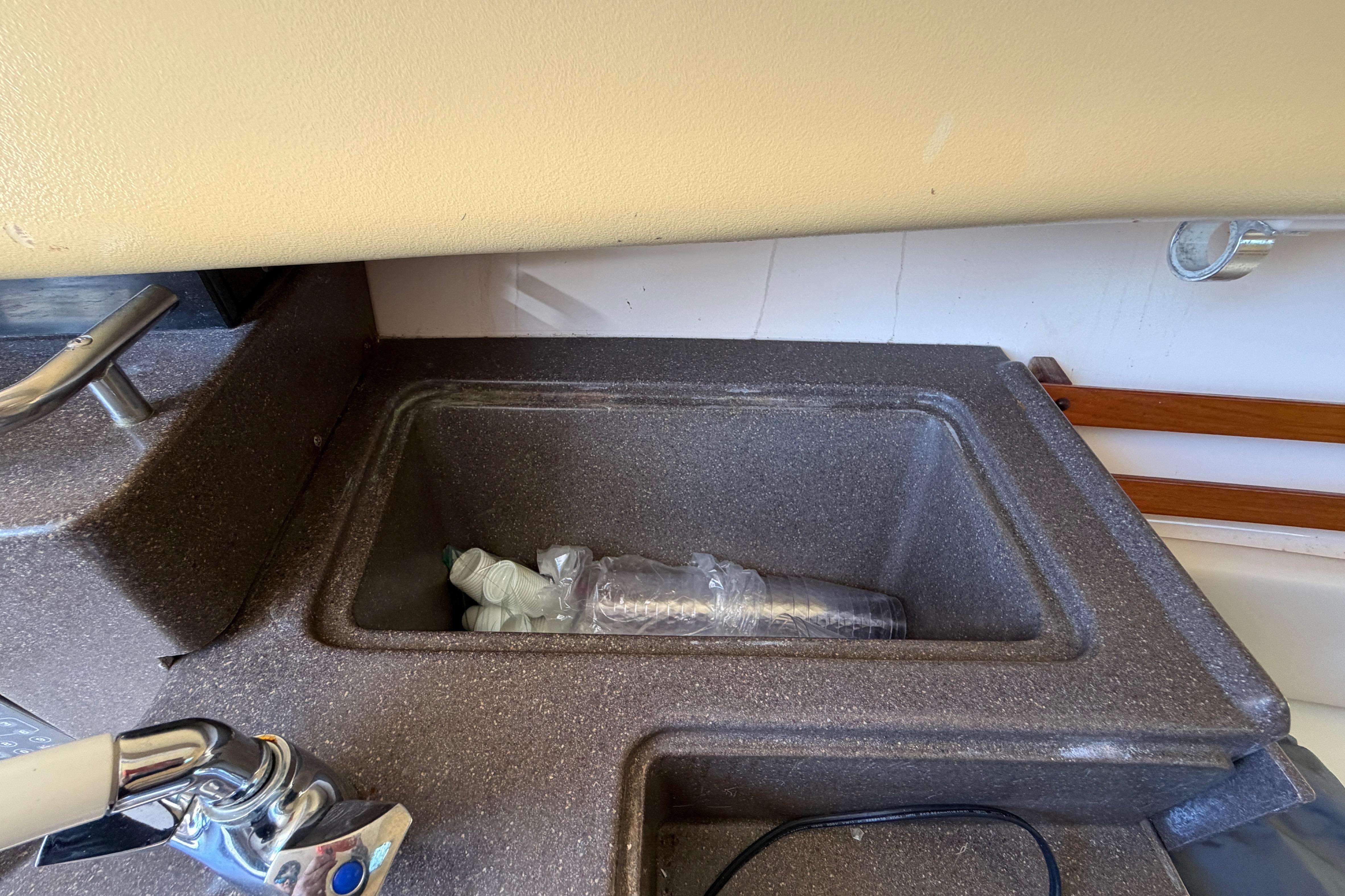 2006 Grady-White Sailfish 282 boat sink with faucet and plastic bottles inside.