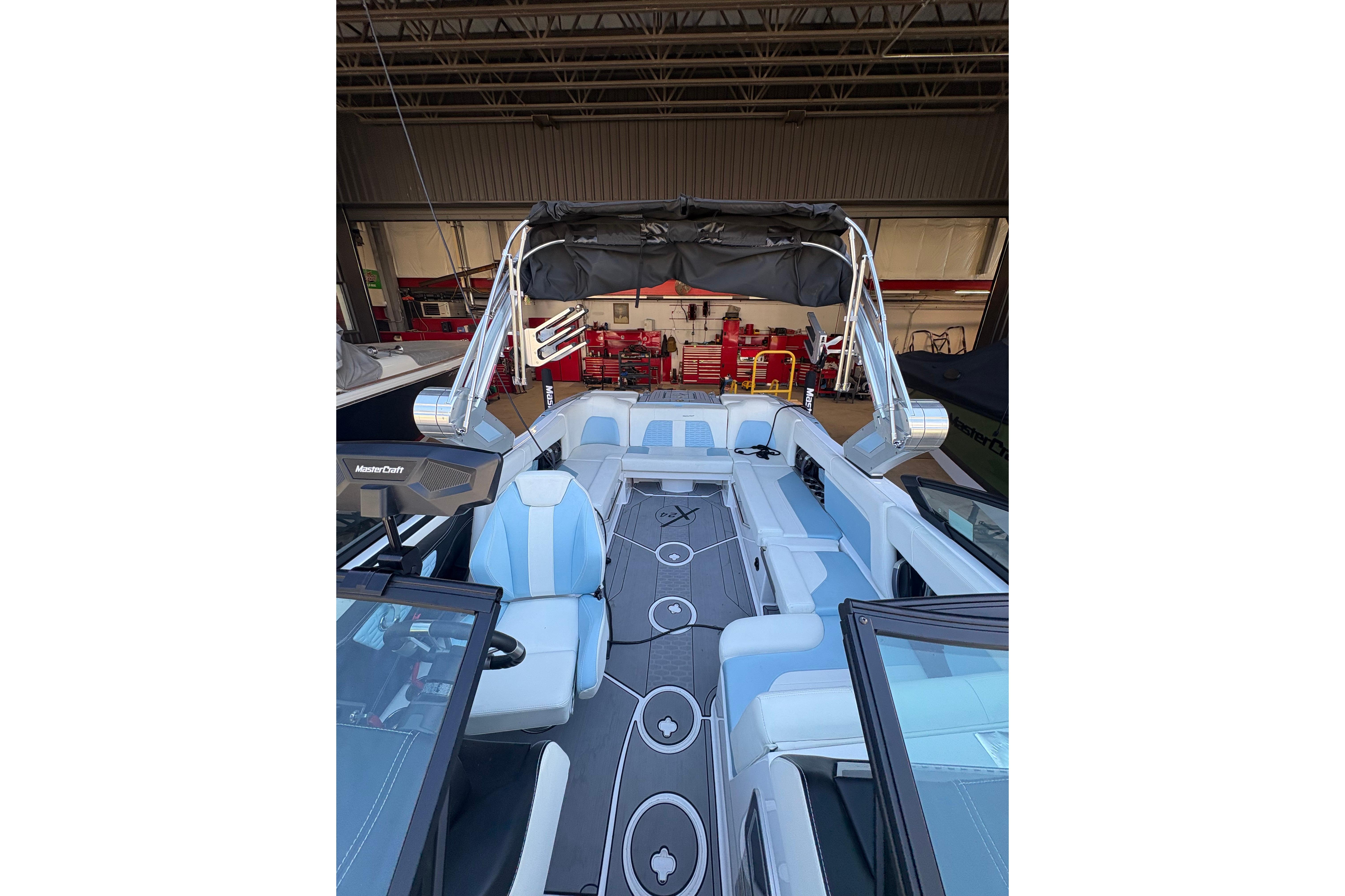 2022 MasterCraft X24 boat interior with sleek seating and modern design in a garage setting.