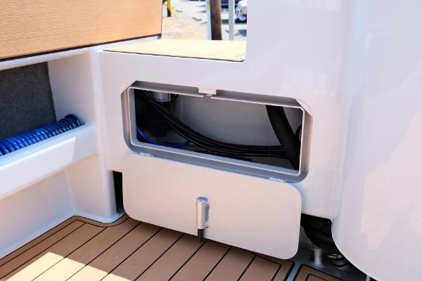 2023 Makaira Gen3 800 boat interior with storage compartment and teak flooring.