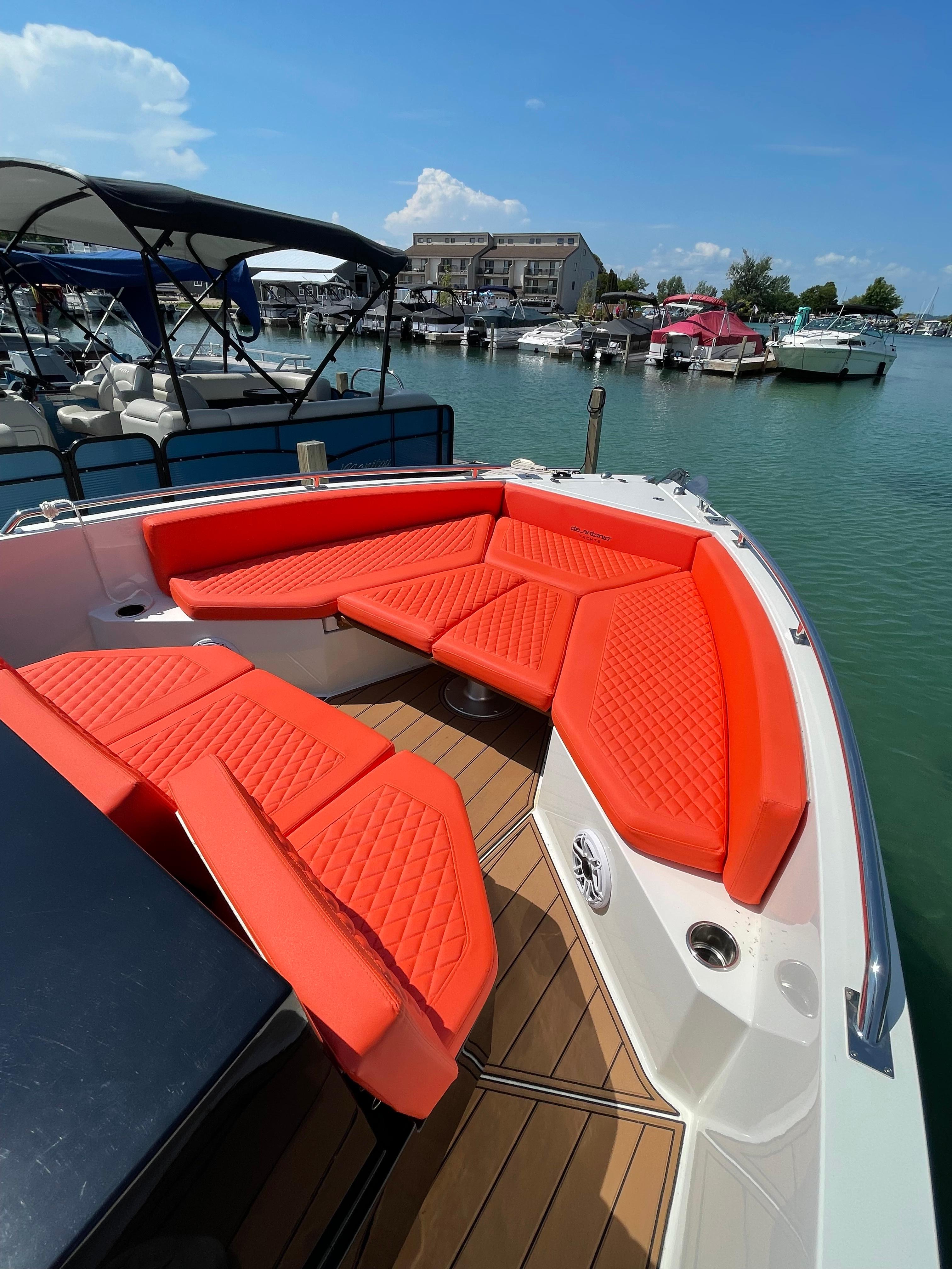 2020 De Antonio Yachts D 28 with vibrant orange seating at a marina.