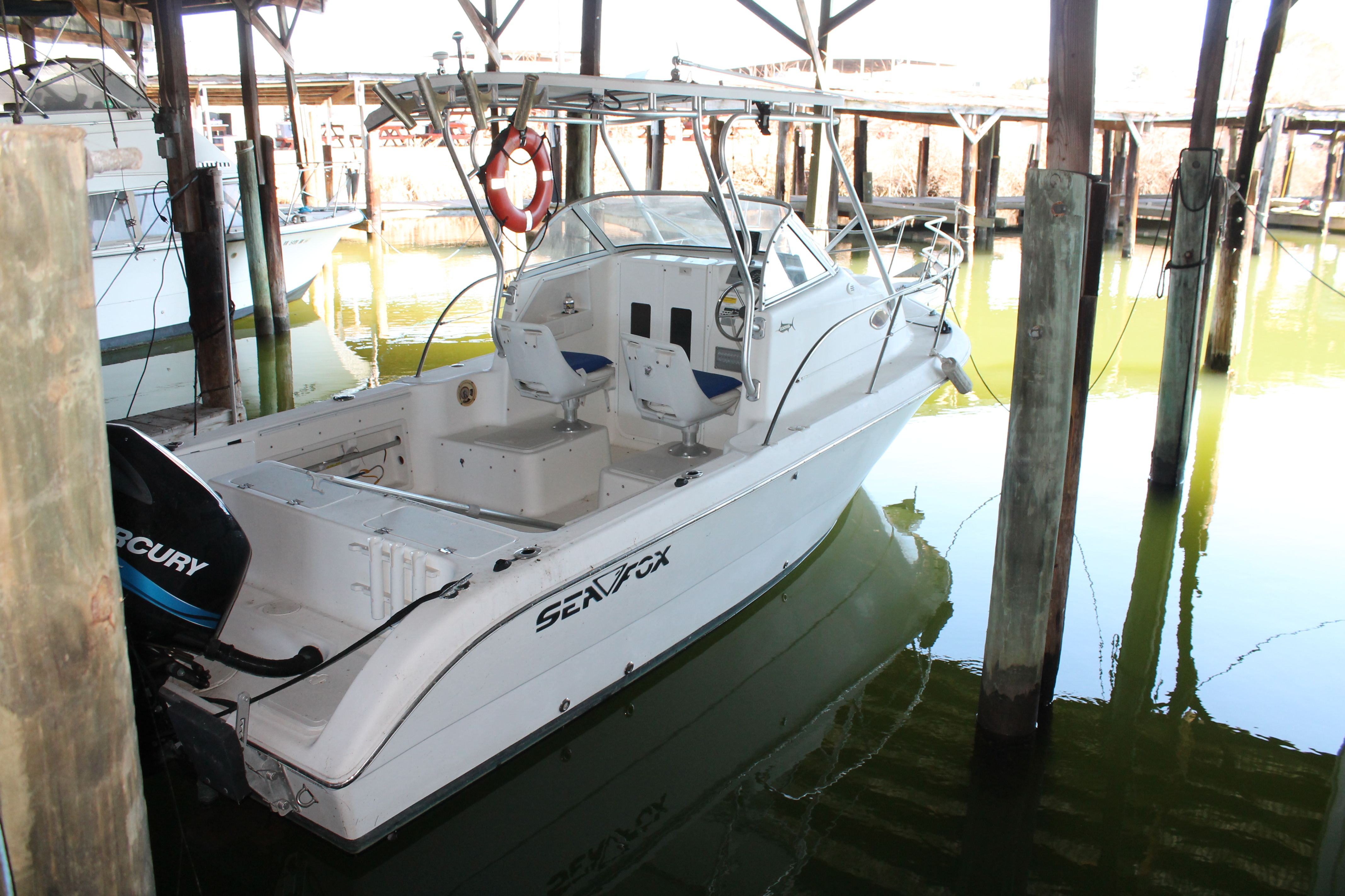 2004 Sea Fox 230 Walk Around boat docked in marina.