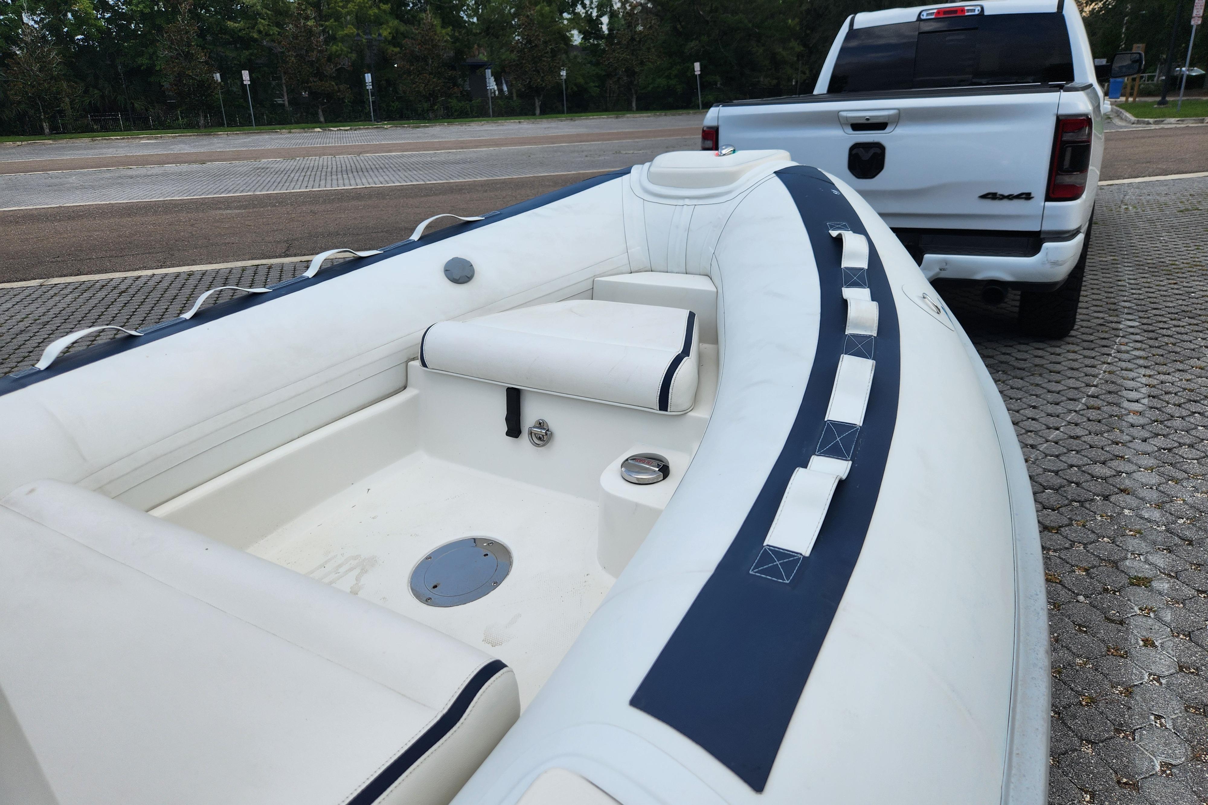 2019 Novurania DL 400 boat on trailer, parked near a white truck.