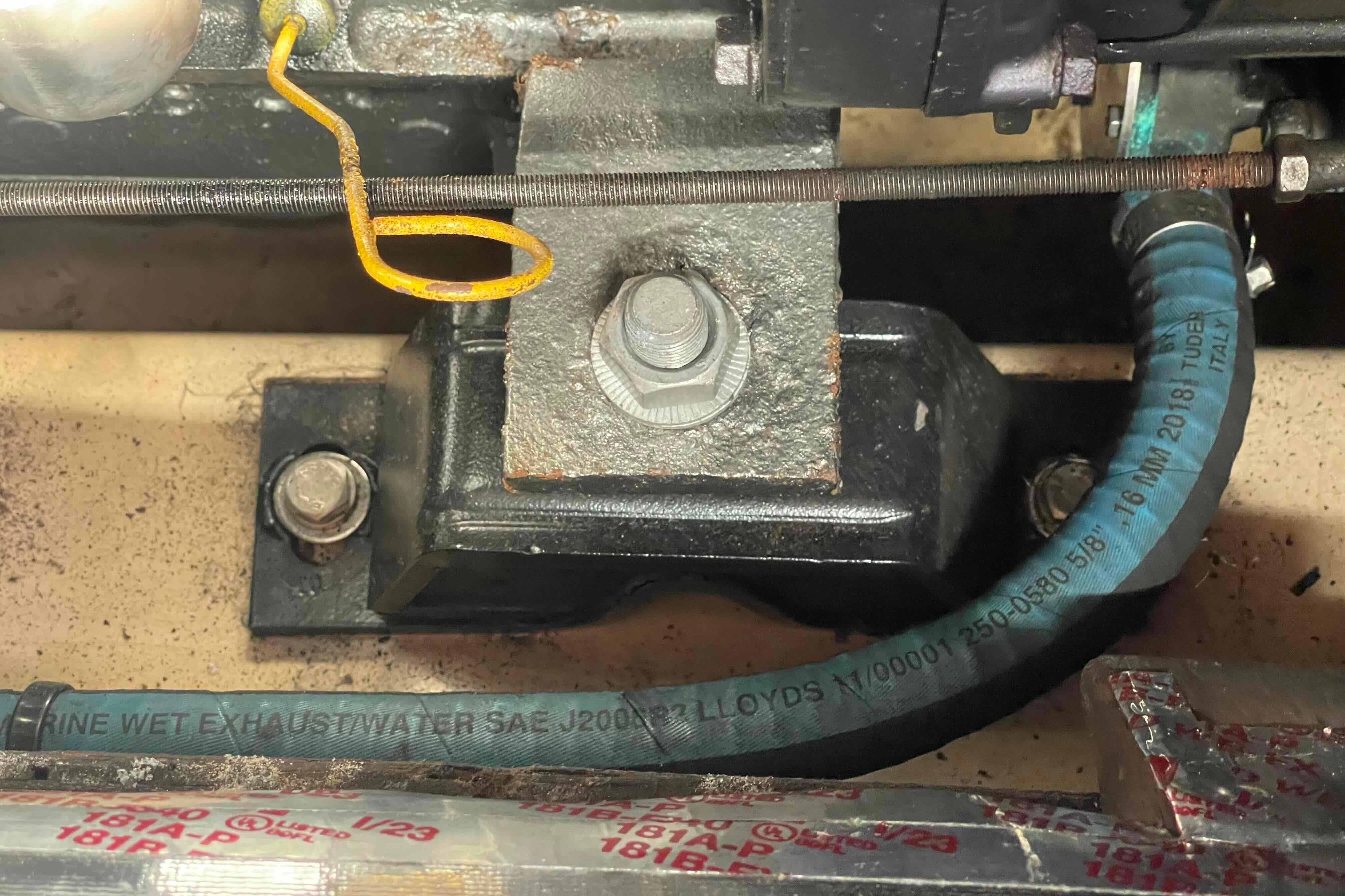Engine component of a 1989 Island Packet 35 sailboat, featuring exhaust hose and mounting bolts.