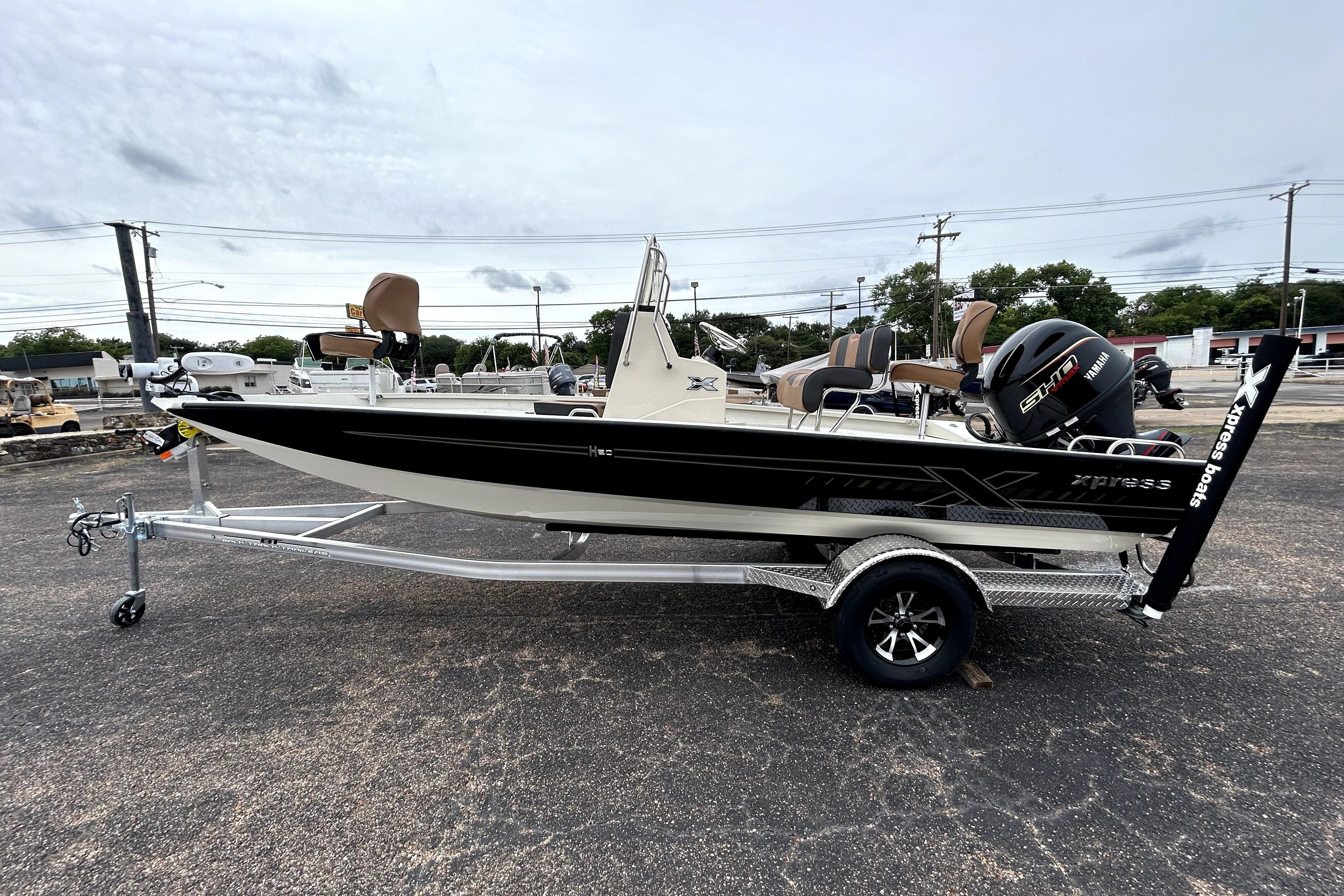 2026 Xpress H20B Bay boat on trailer, featuring Yamaha engine, parked outdoors.