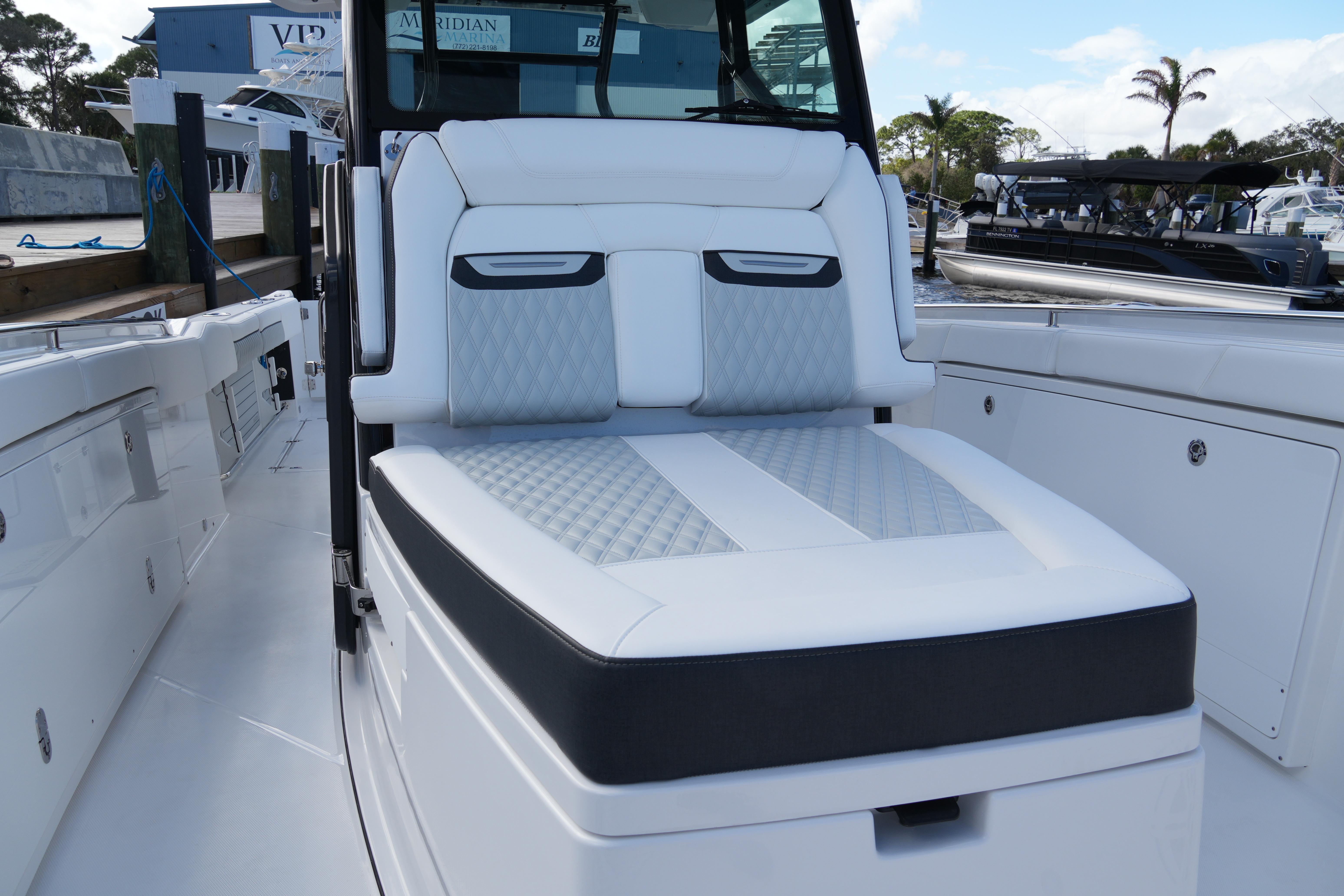 2026 Blackfin 332 CC boat with luxurious seating at a marina.