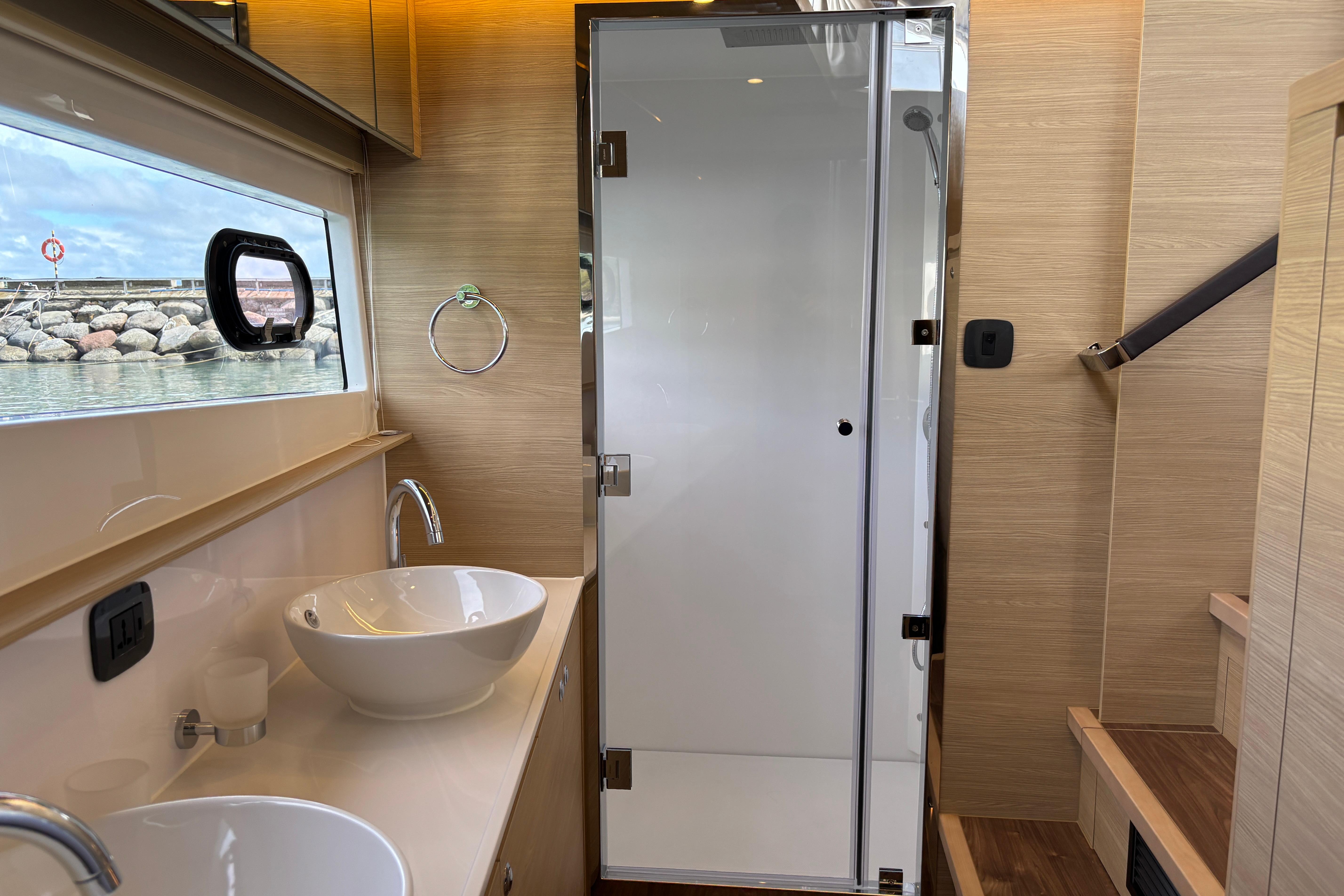 Luxurious bathroom interior of 2025 Aquila 54 Yacht with modern fixtures and ocean view.