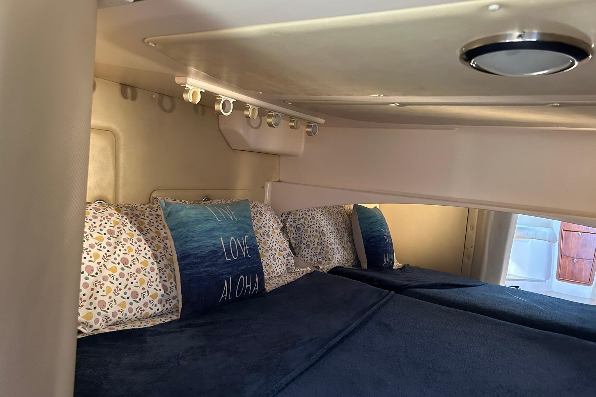 Cozy cabin interior of 2007 Grady-White Express 360 with decorative pillows and bedding.