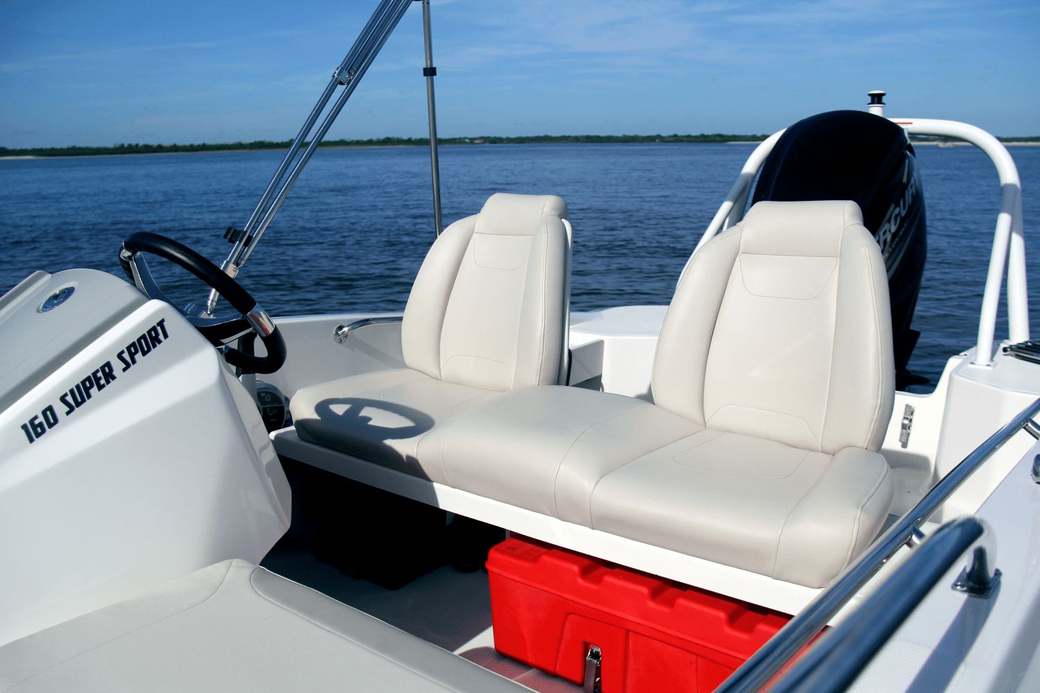 The image shows a Boston Whaler 160 Super Sport boat on the water with white seats.