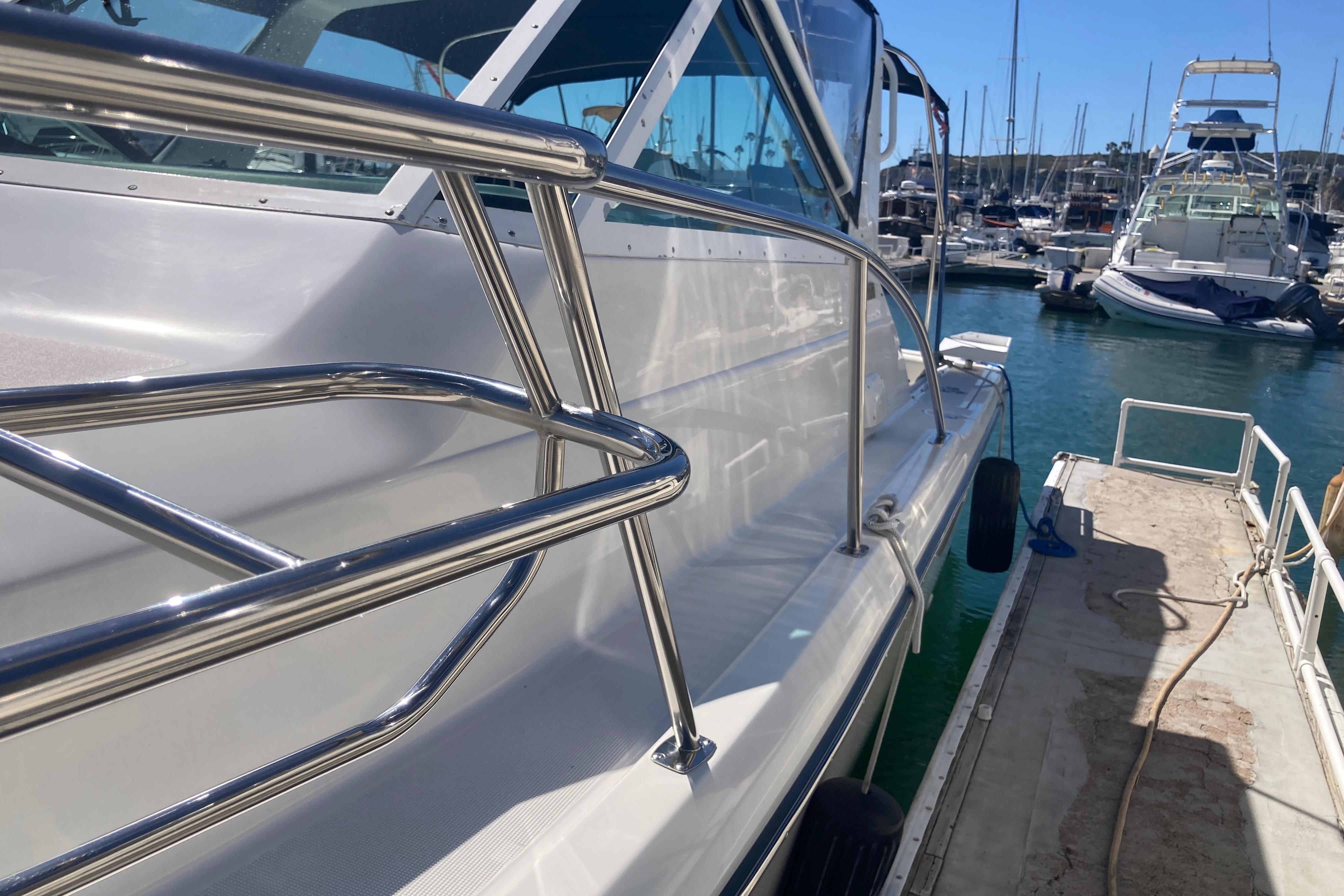 2002 Tiara Yachts 2900 Open docked at marina, showcasing sleek design and stainless steel railings.