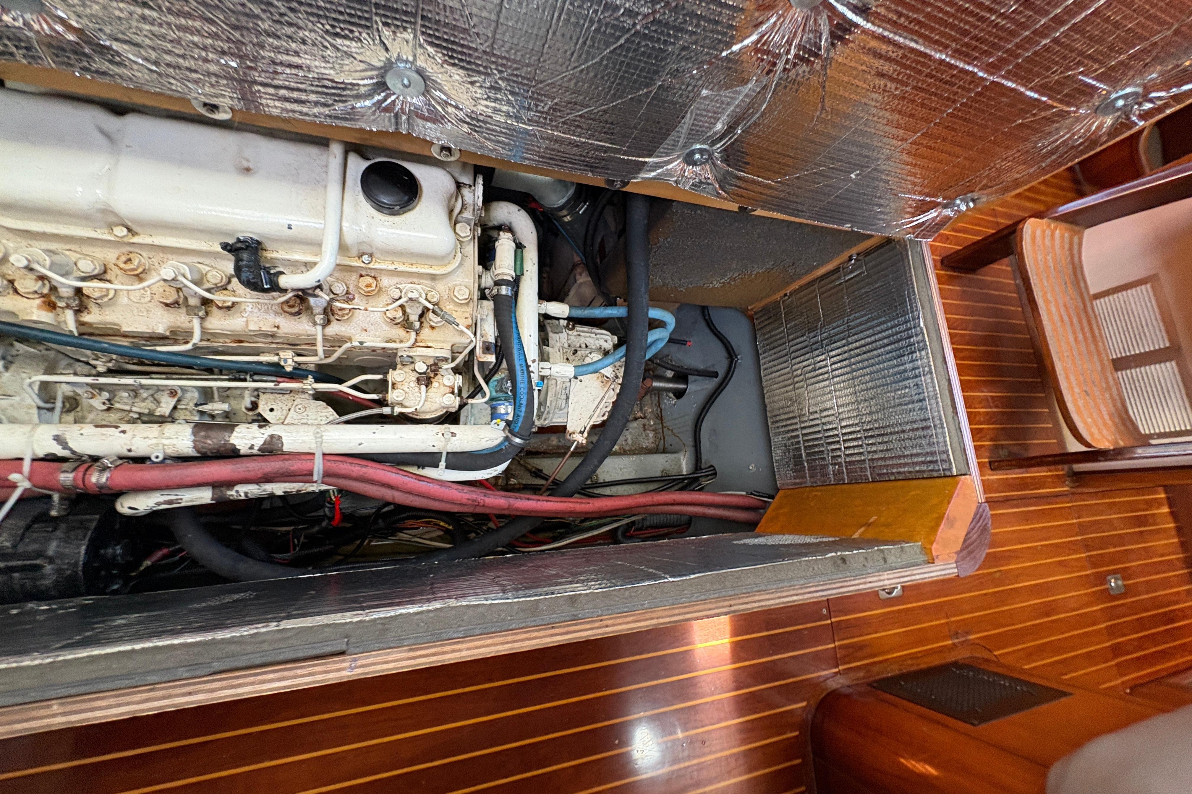 Engine compartment of 1990 Beneteau Oceanis 500 sailboat, showcasing mechanical components and insulation.