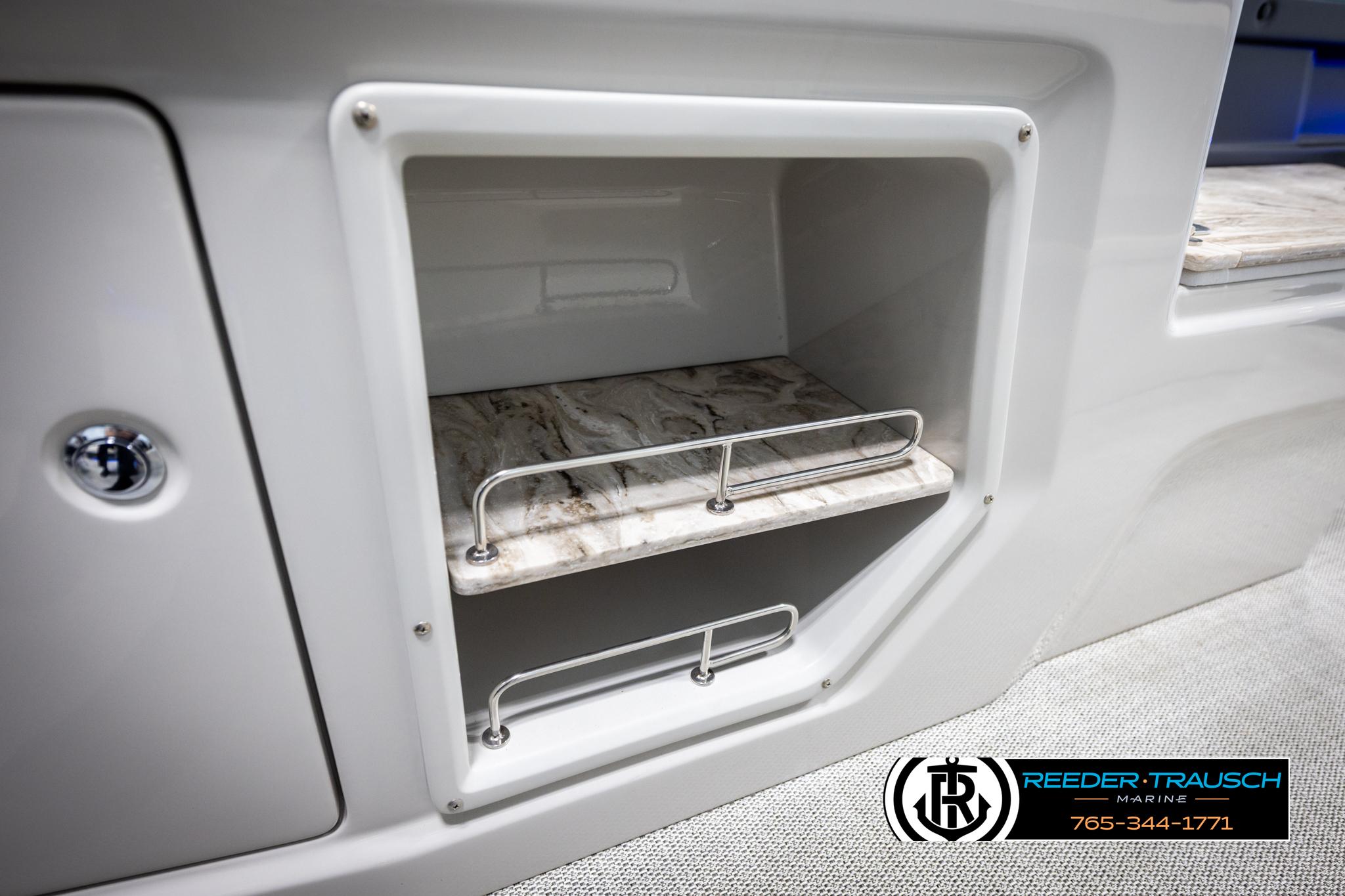 Storage compartment in 2025 Avalon 2585 Excal VRBW boat with marble-like shelves.