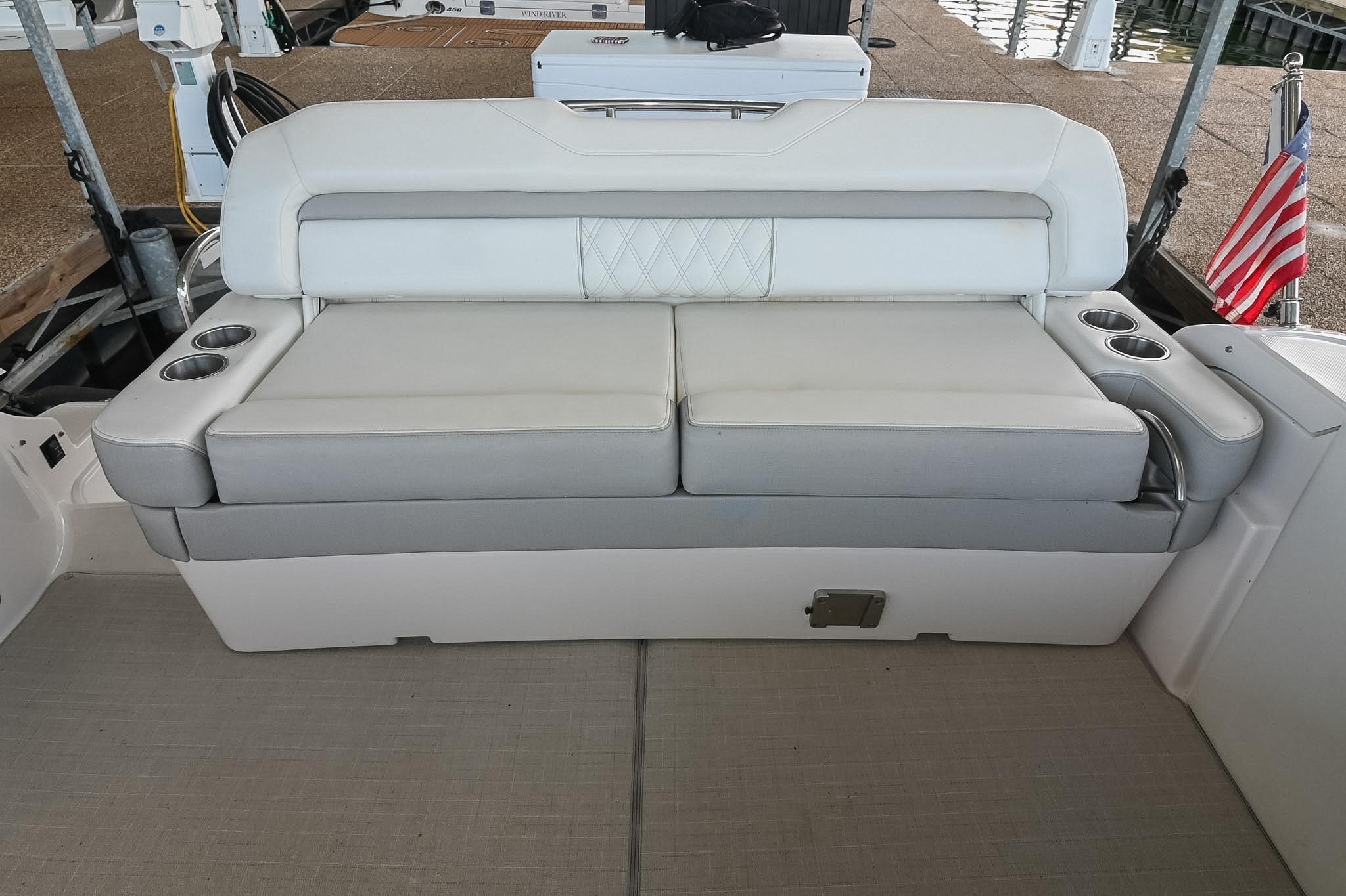 Luxury seating on a 2021 Regal 33 Express boat with cup holders and American flag.