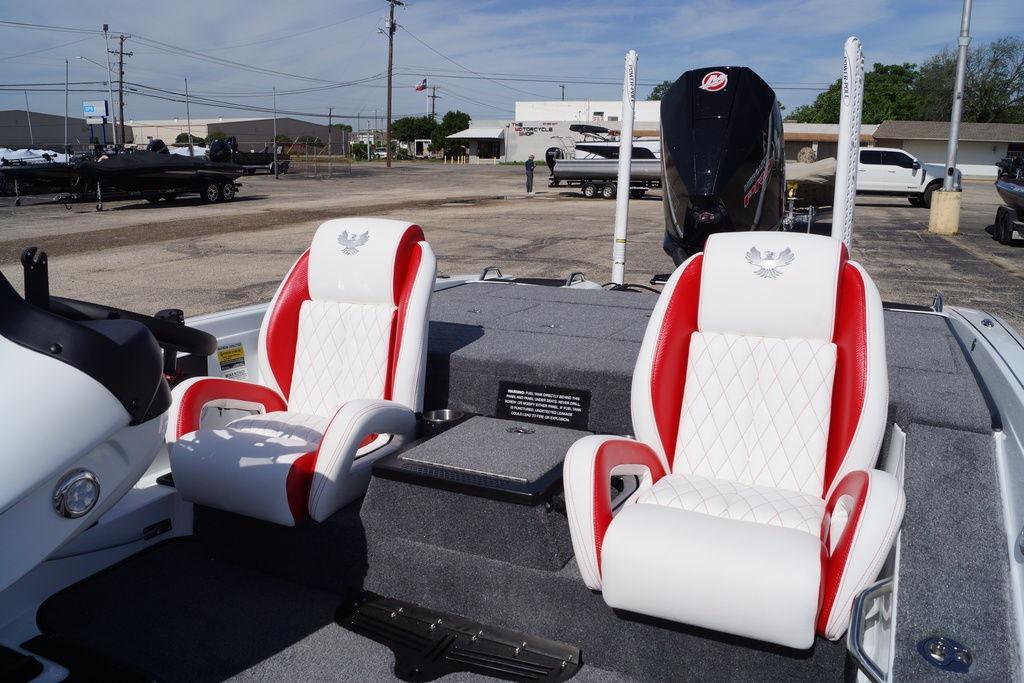2026 Phoenix 721 ZXL boat with red and white seats, parked outdoors.