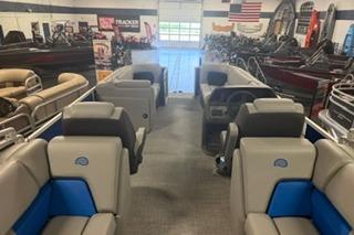 2026 Sun Tracker Party Barge 22 DLX interior with seating, displayed in showroom.