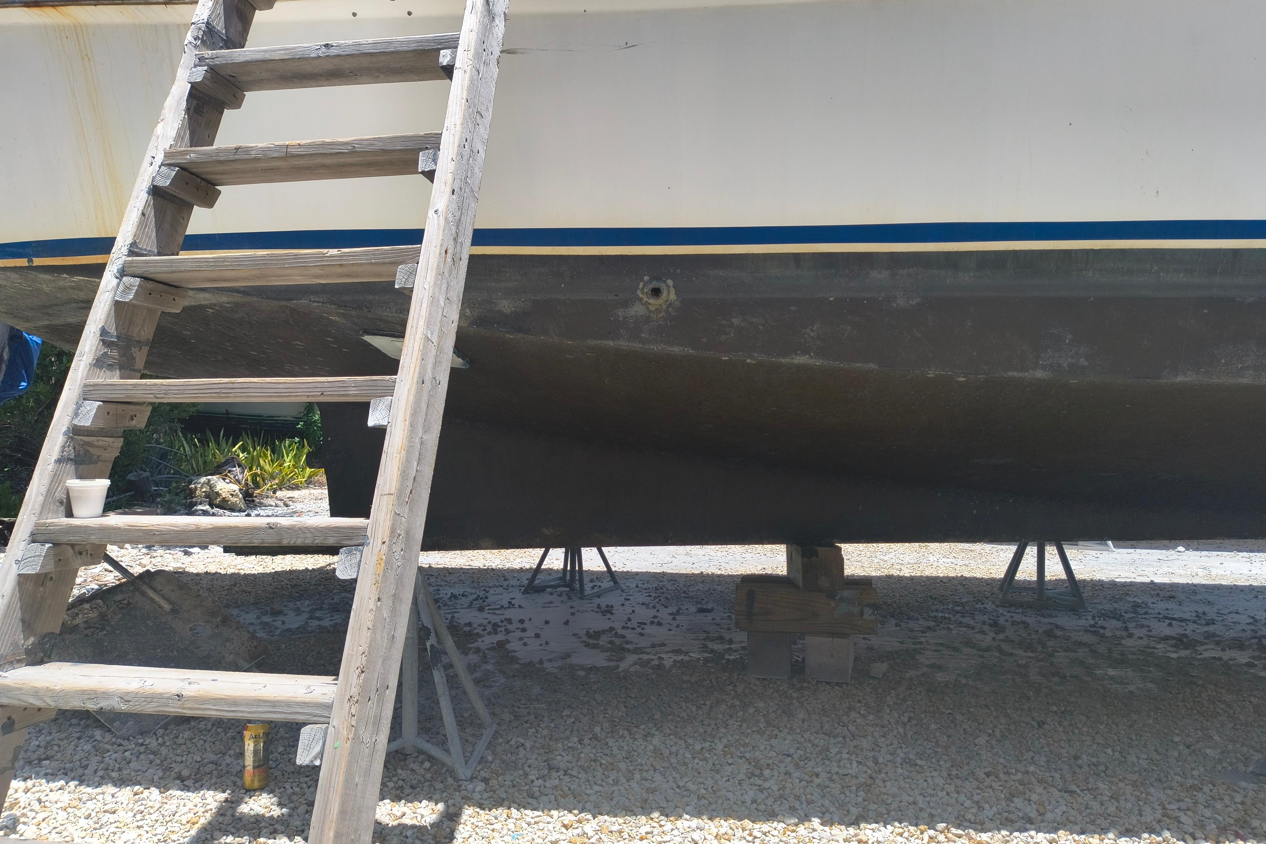 1984 Kadey-Krogen Manatee boat on stands with wooden ladder beside it.