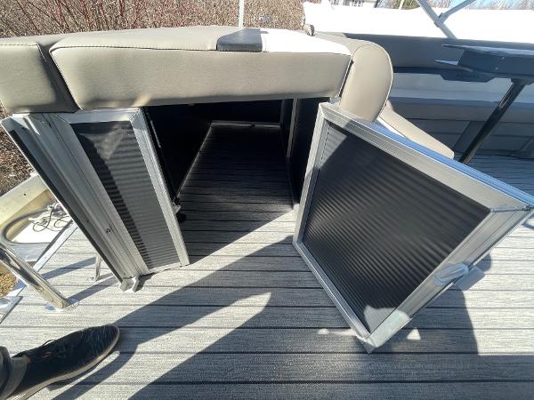2025 Armada Saphir 23CR boat storage compartment with open doors on striped deck.