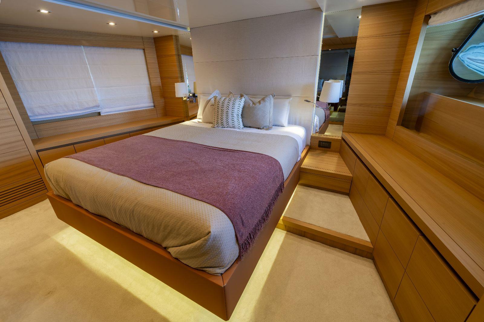 Luxurious bedroom interior of 2011 Maiora 27 yacht with modern design and cozy bedding.