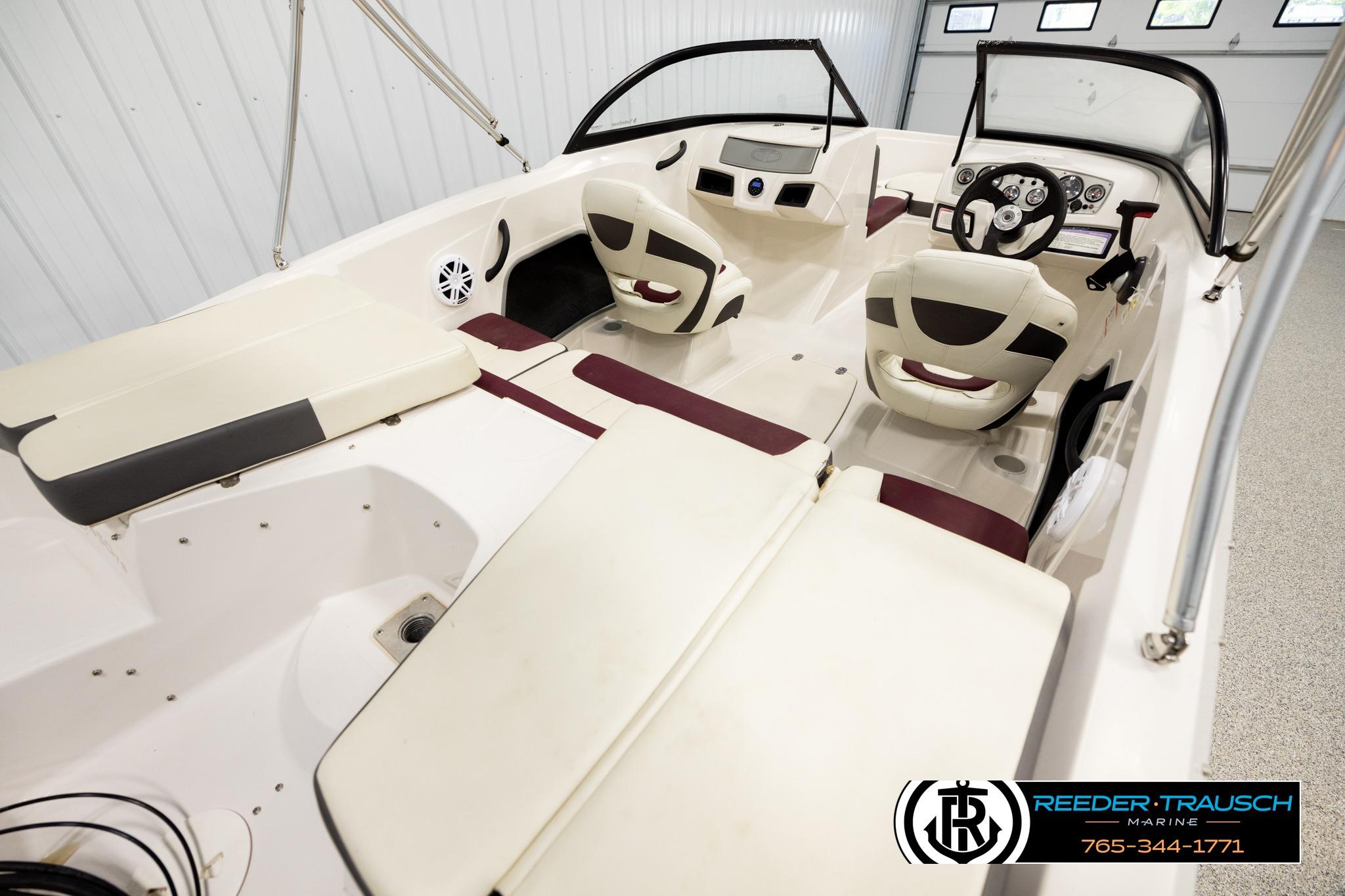 2016 Tahoe 450 TS boat interior with seating and steering wheel in showroom.