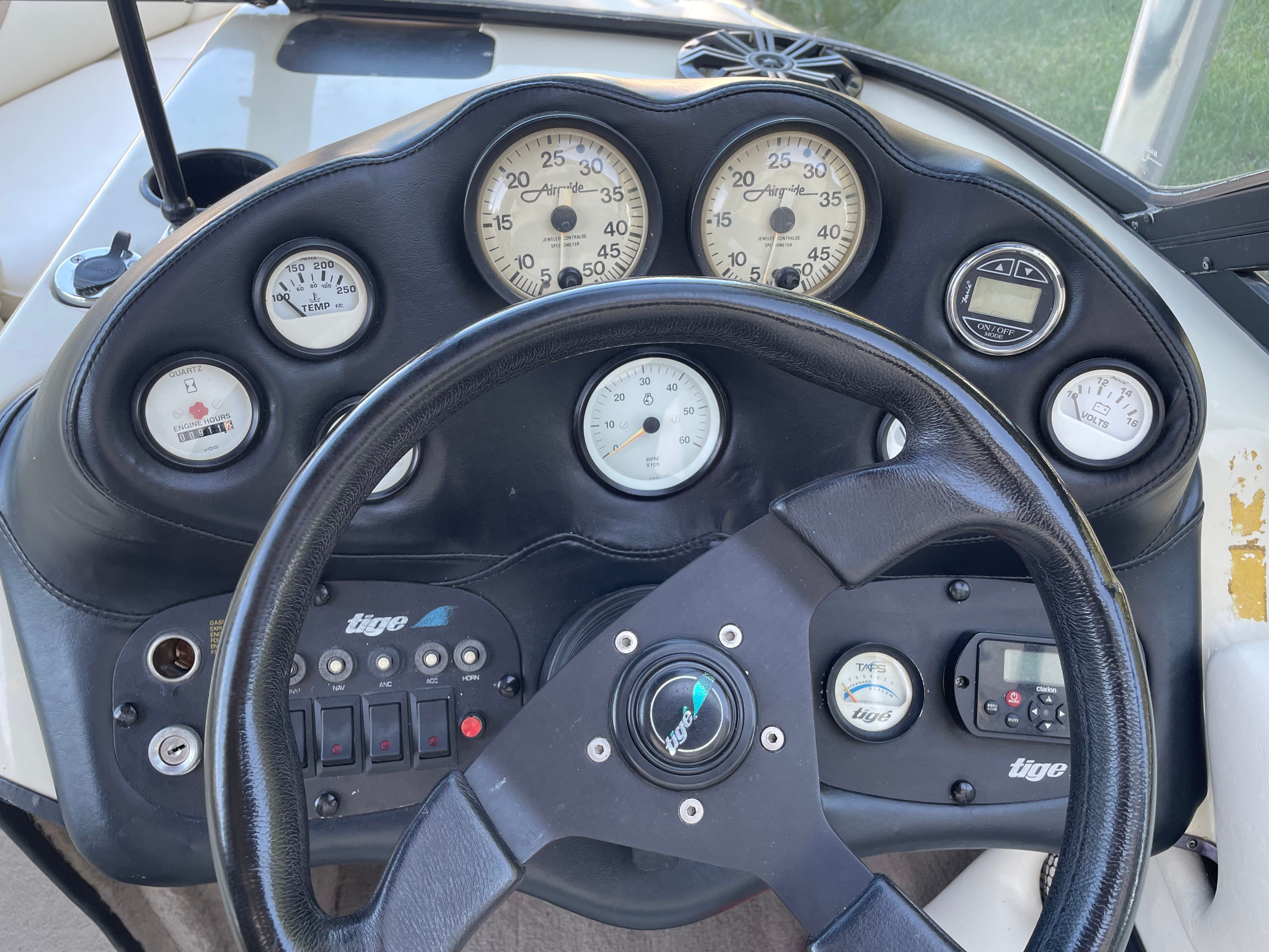 Dashboard of a 1998 Tigé Pre 2100 with multiple gauges and a black steering wheel.