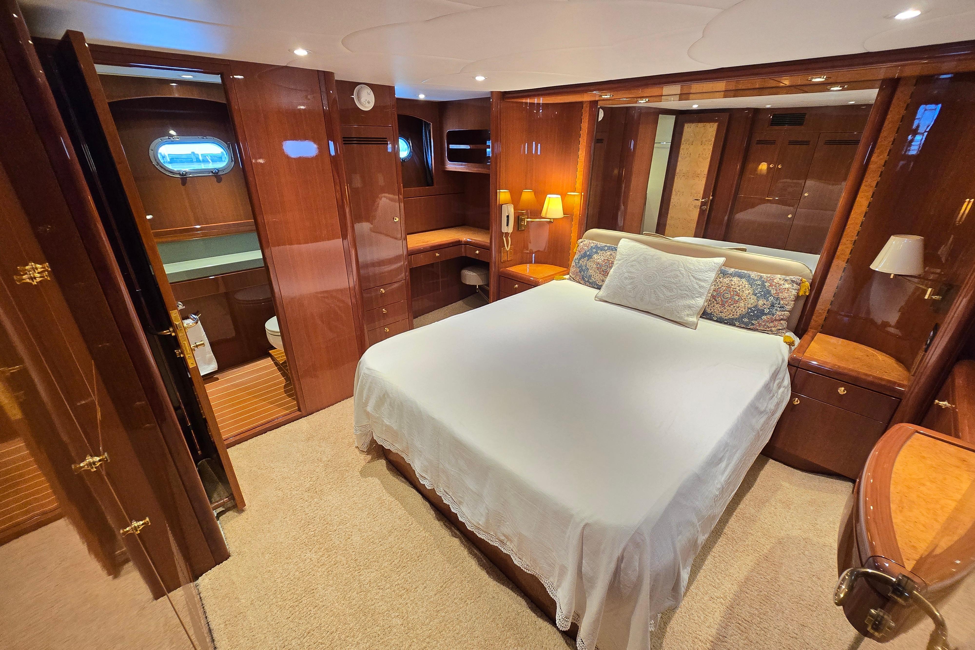 Luxurious bedroom interior of 2004 Grand Harbour 58 yacht with elegant wood finishes.