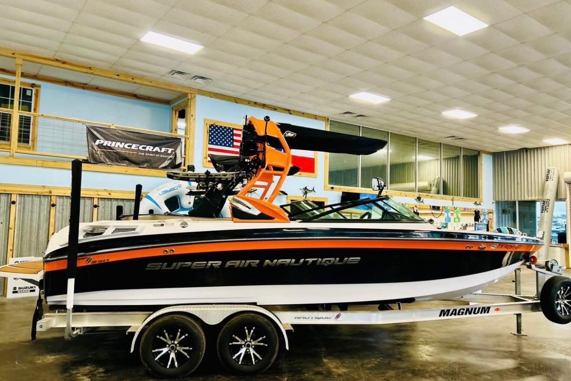 2013 Nautique Super Air Nautique 230 boat on trailer in showroom.