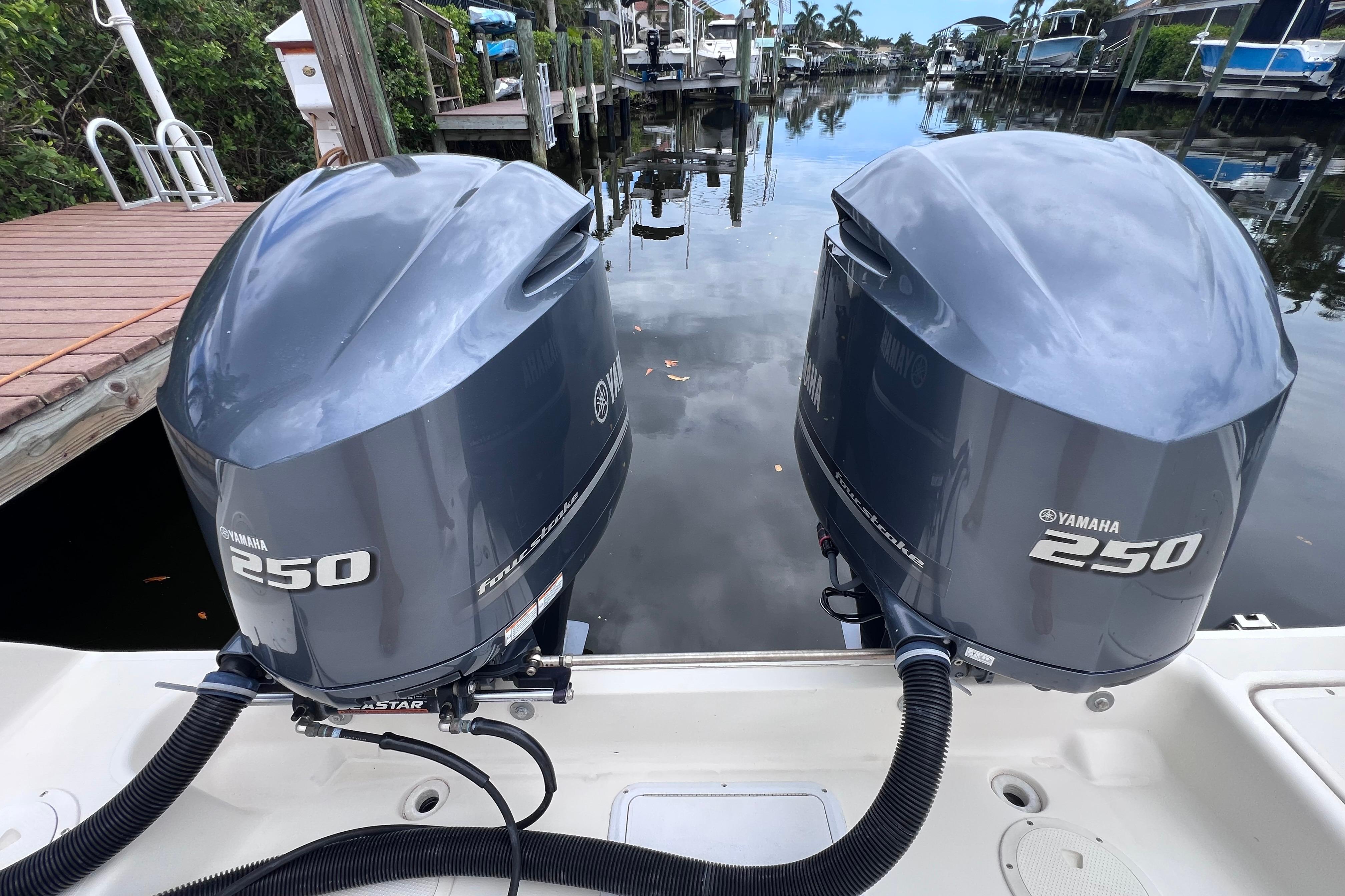 Twin Yamaha 250 outboard engines on a 2005 Pursuit 3070 Offshore boat at a dock.