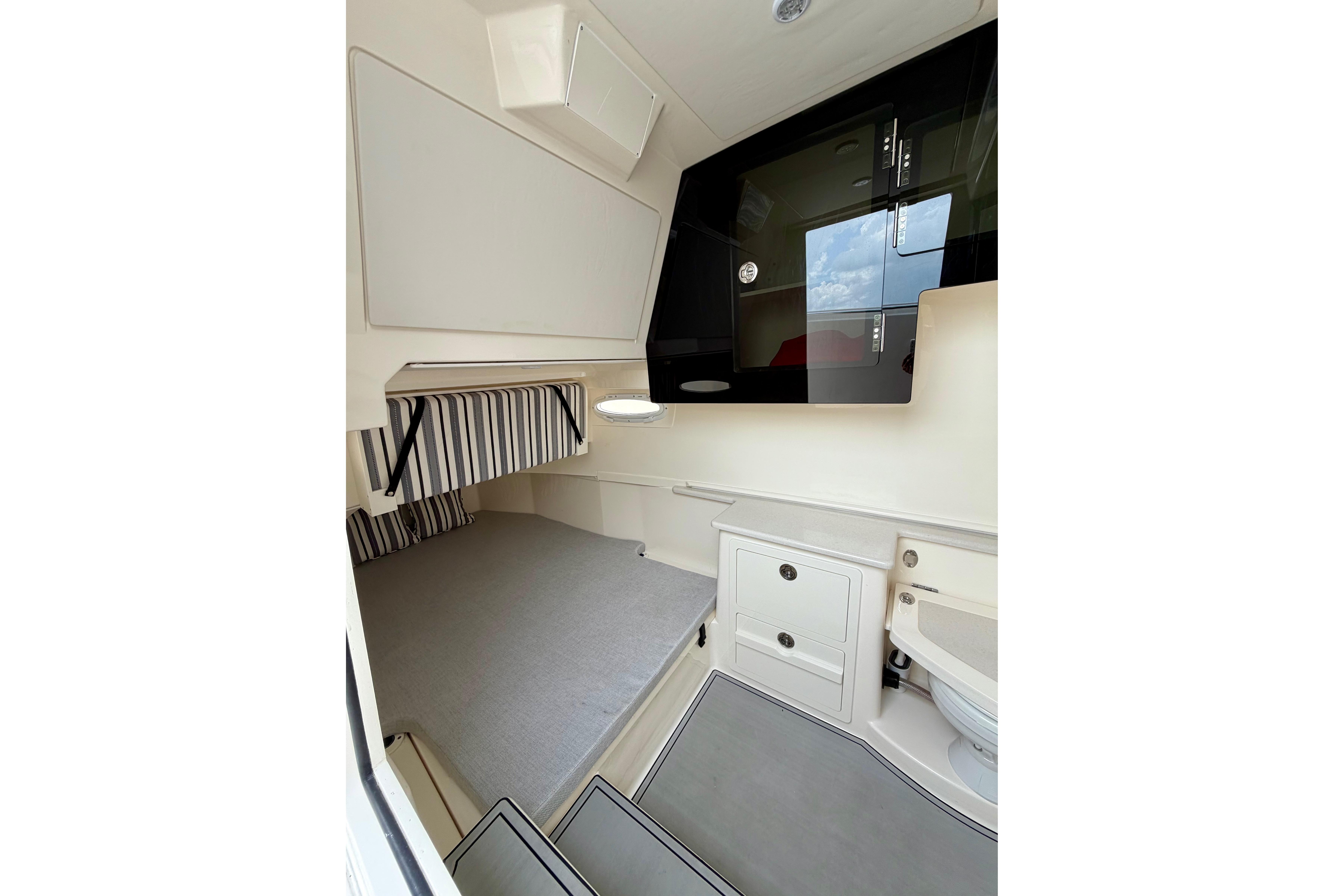 2023 Cobia 350 Center Console cabin interior with bed, storage, and modern design.