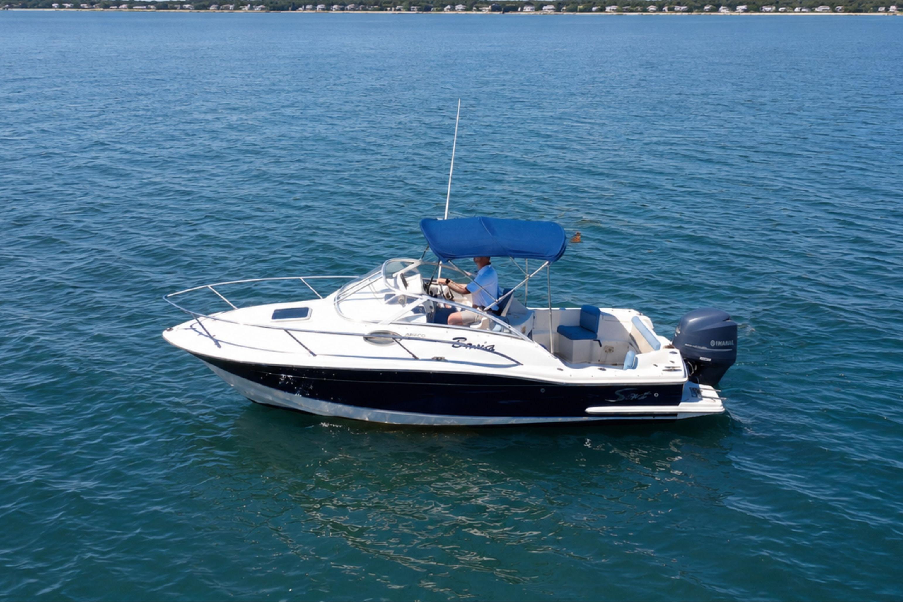 2008 Scout 222 Abaco boat cruising on open water with blue canopy.