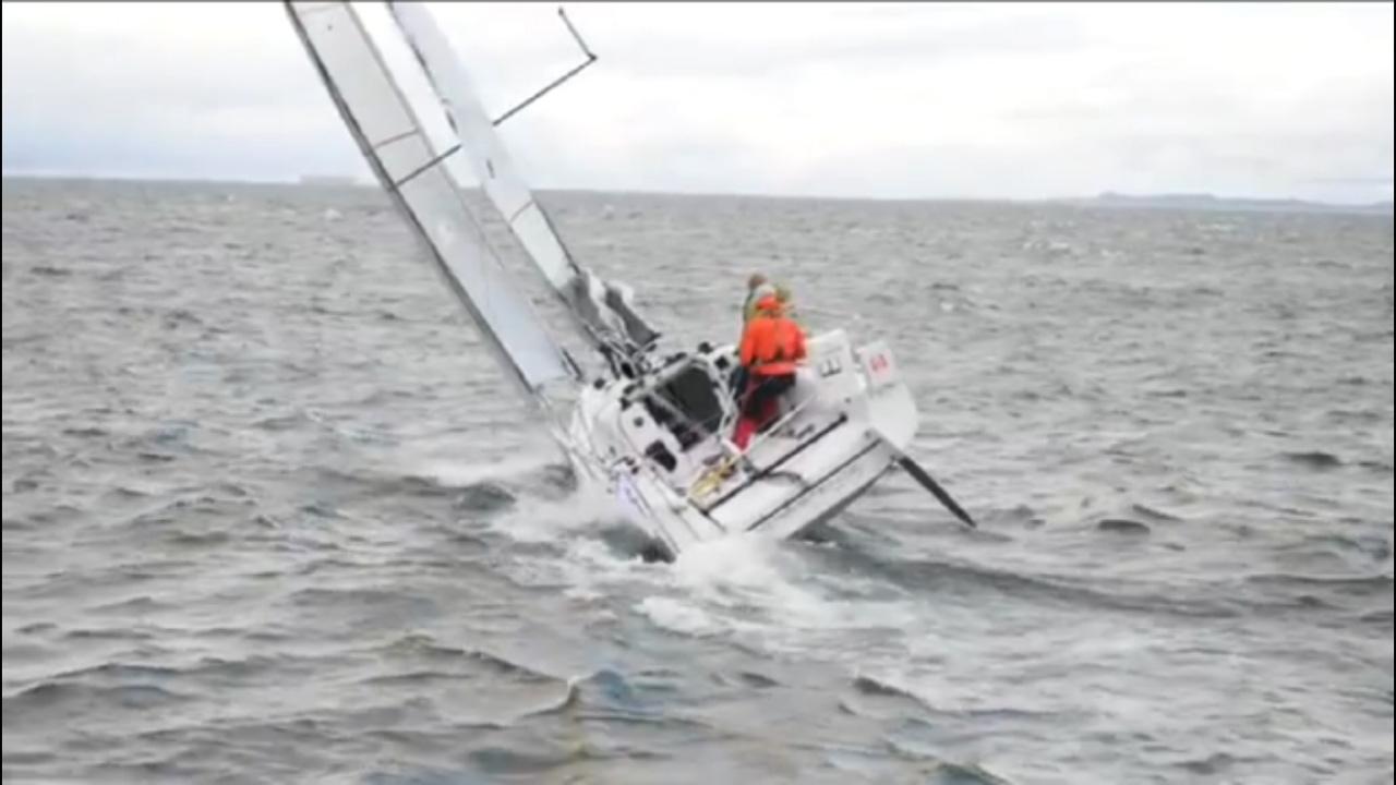 Sailboat Seascape 27 navigating rough waters, 2018 model, with crew in orange gear.