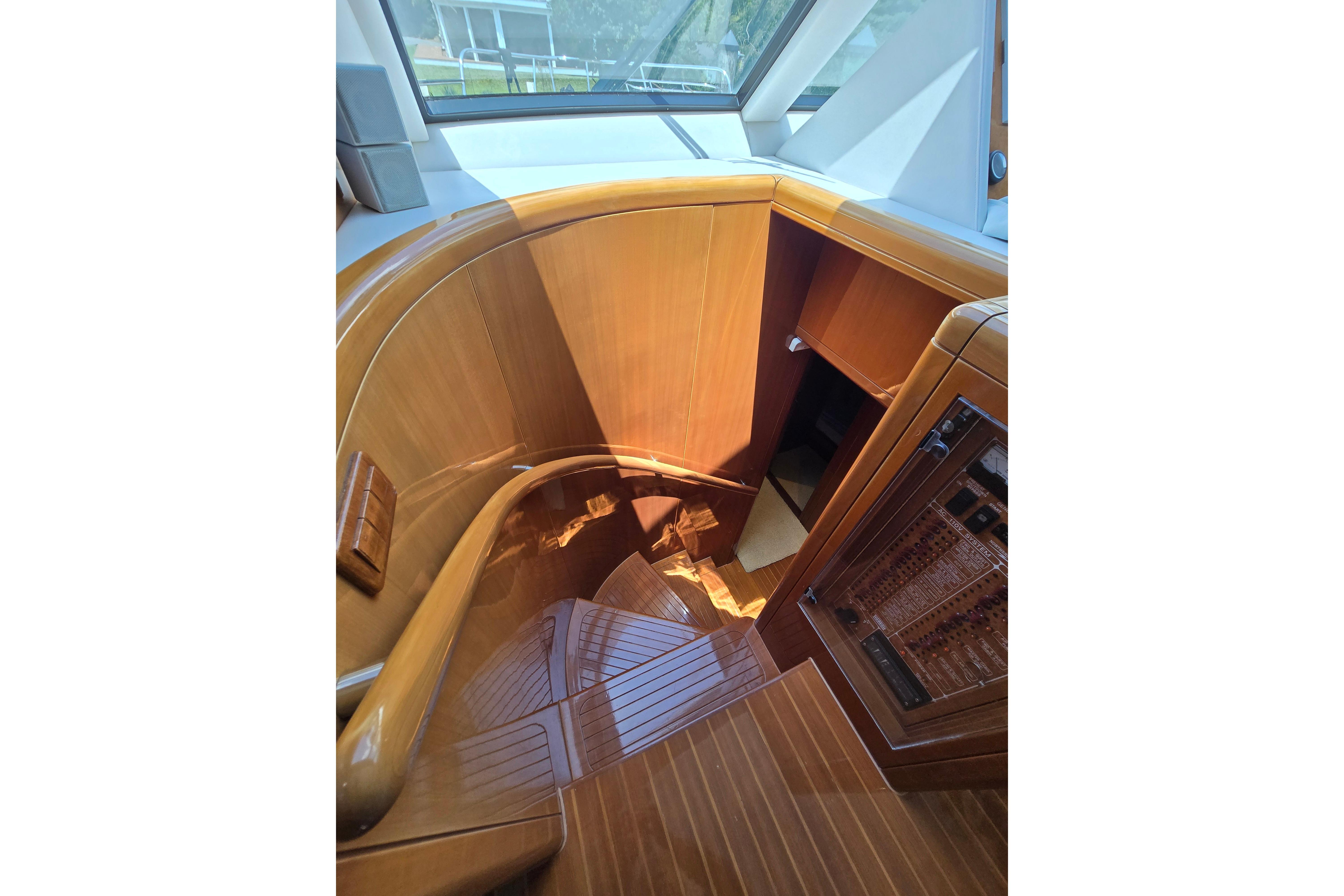 Luxurious wooden staircase inside 2004 Grand Harbour 58 yacht, showcasing elegant craftsmanship.