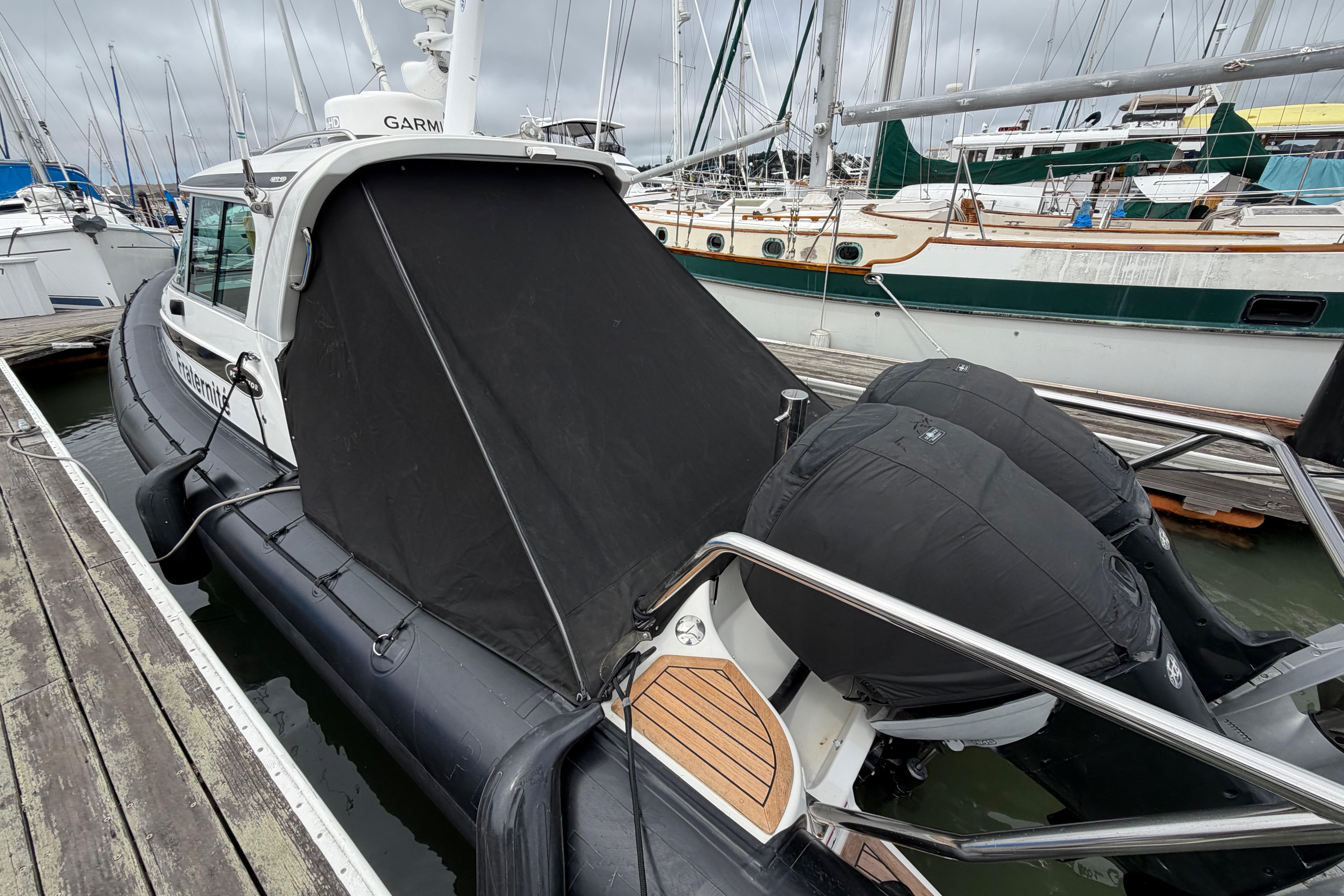 2016 Protector Targa 30 boat docked, featuring covered engines and sleek design.