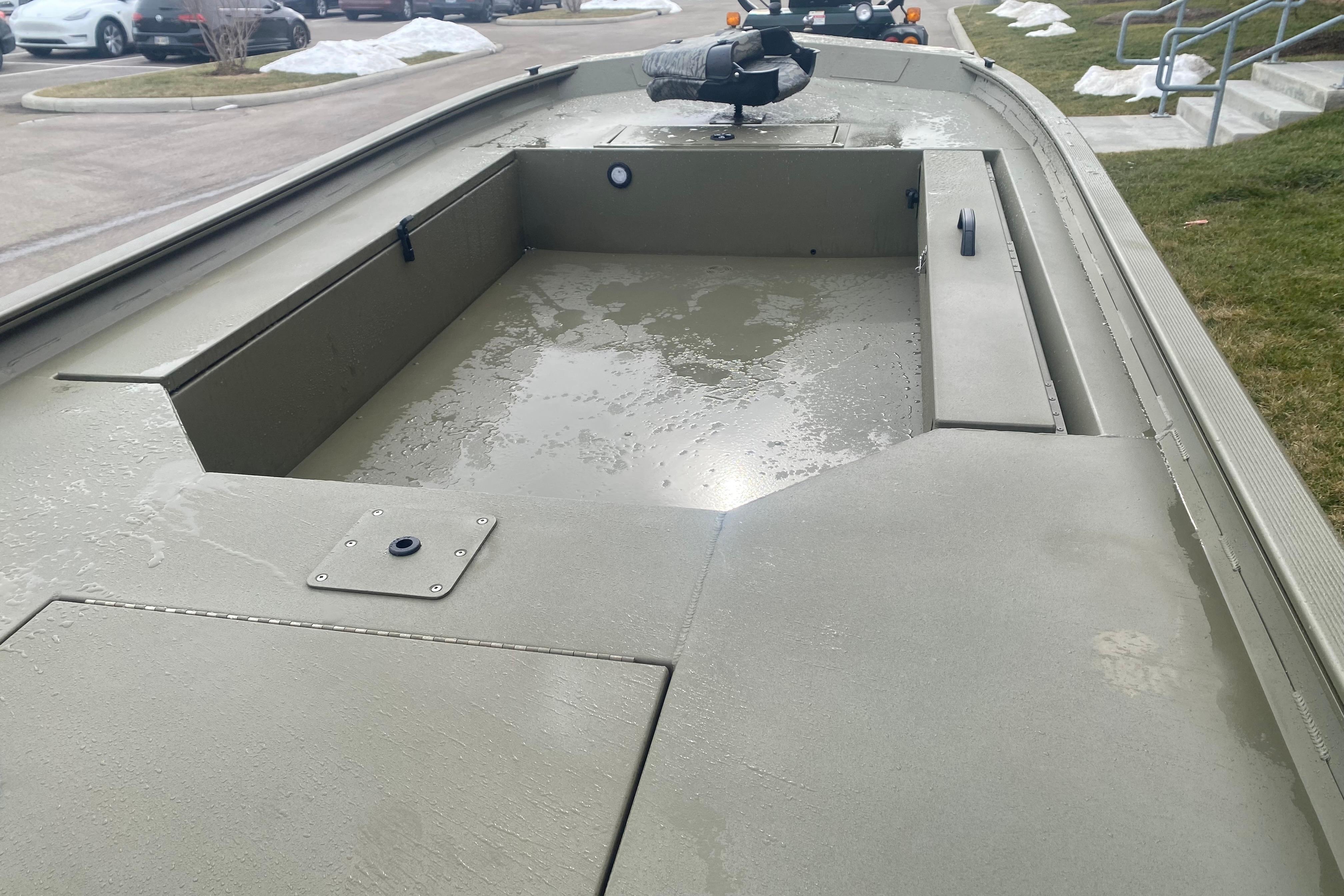 2026 Tracker Grizzly 1654 T Sportsman boat interior with wet surfaces, parked outdoors.