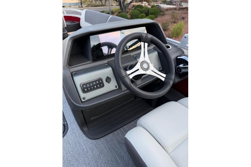 2026 Sun Tracker Fishin' Barge 22 XP3 steering console with modern controls and comfortable seating.