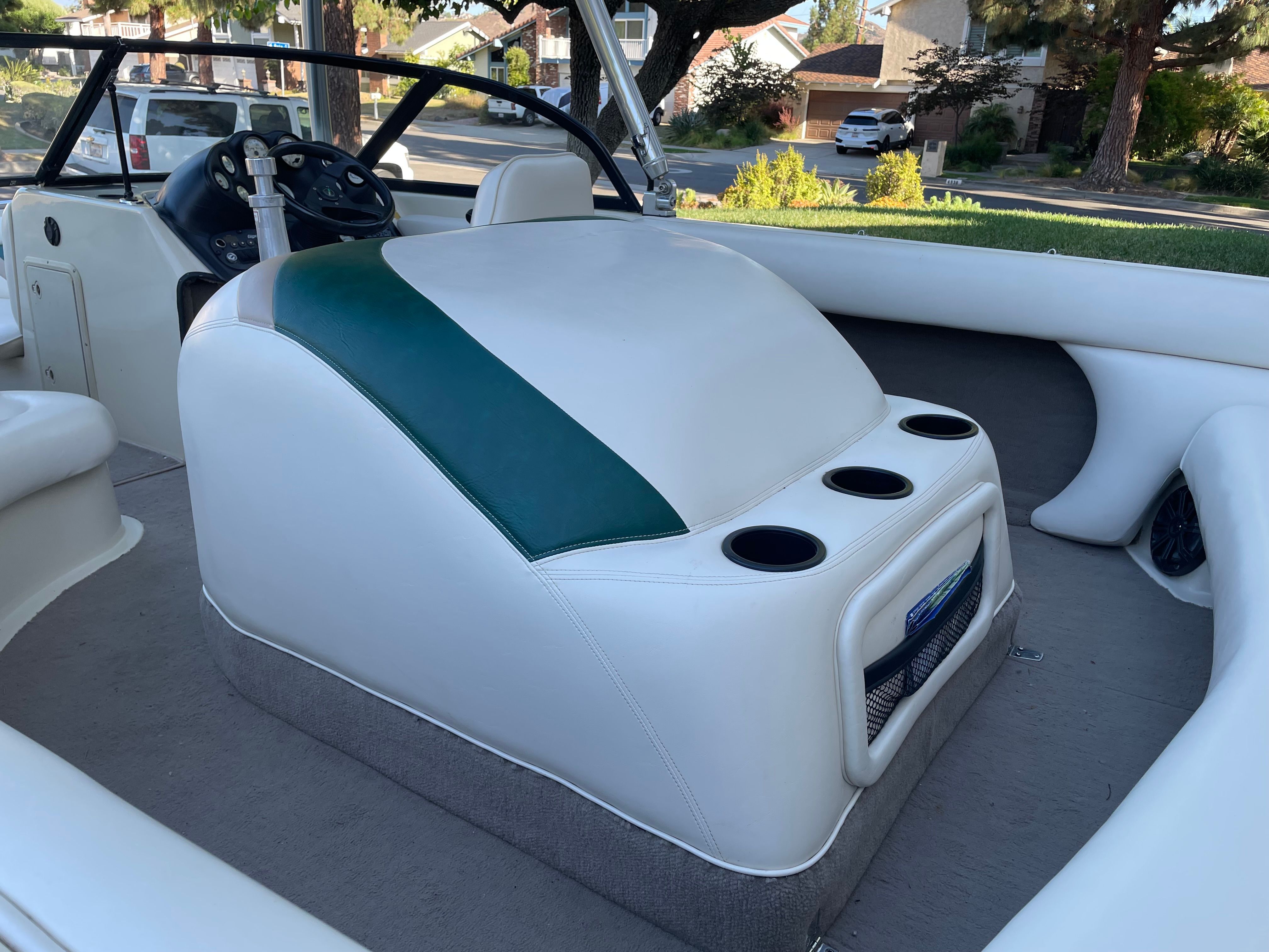 Interior of a 1998 Tigé Pre 2100 with white and green upholstery and cup holders.