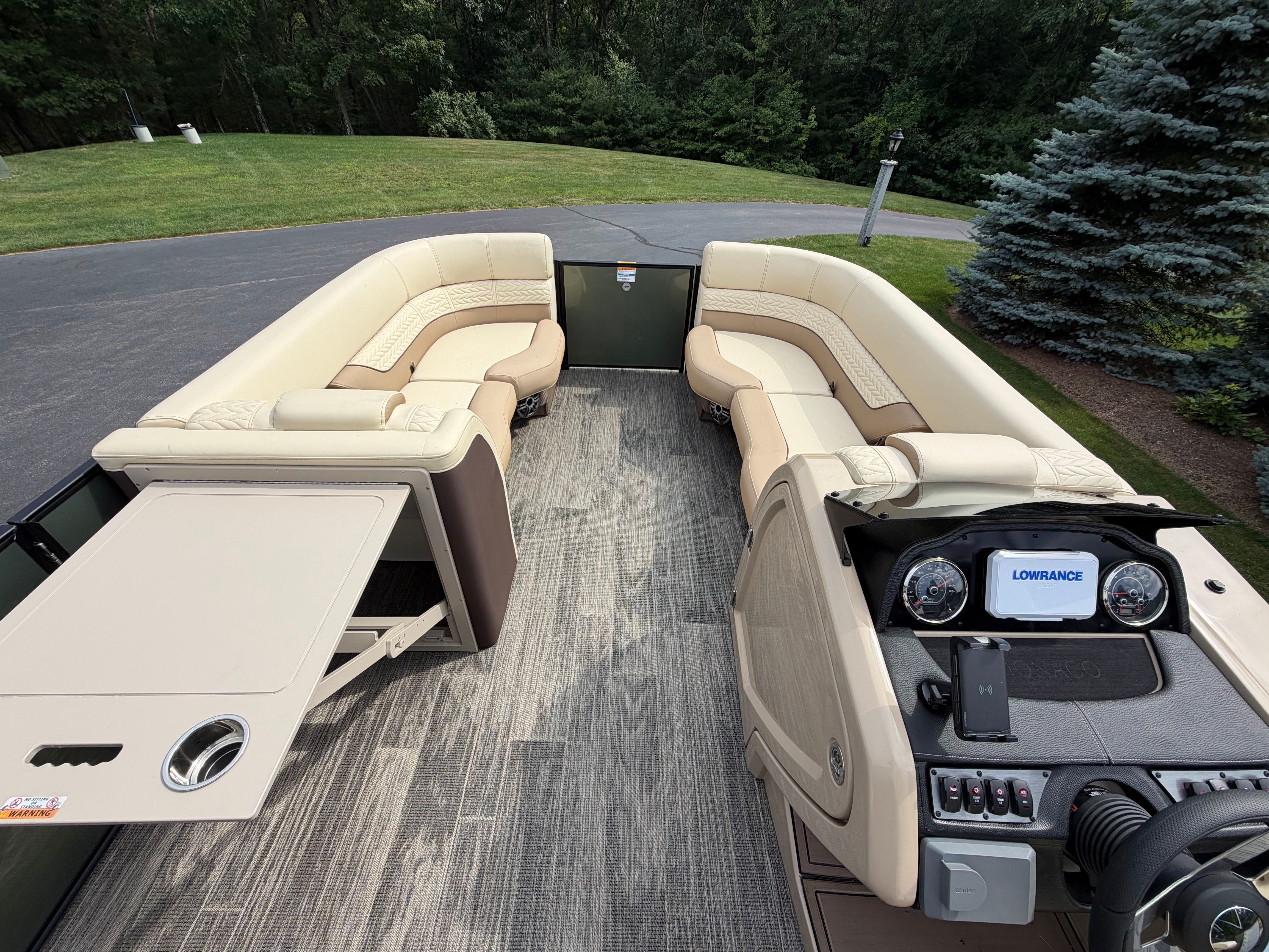 Interior of a 2025 Godfrey Monaco Cruise with beige seating and a modern helm station.