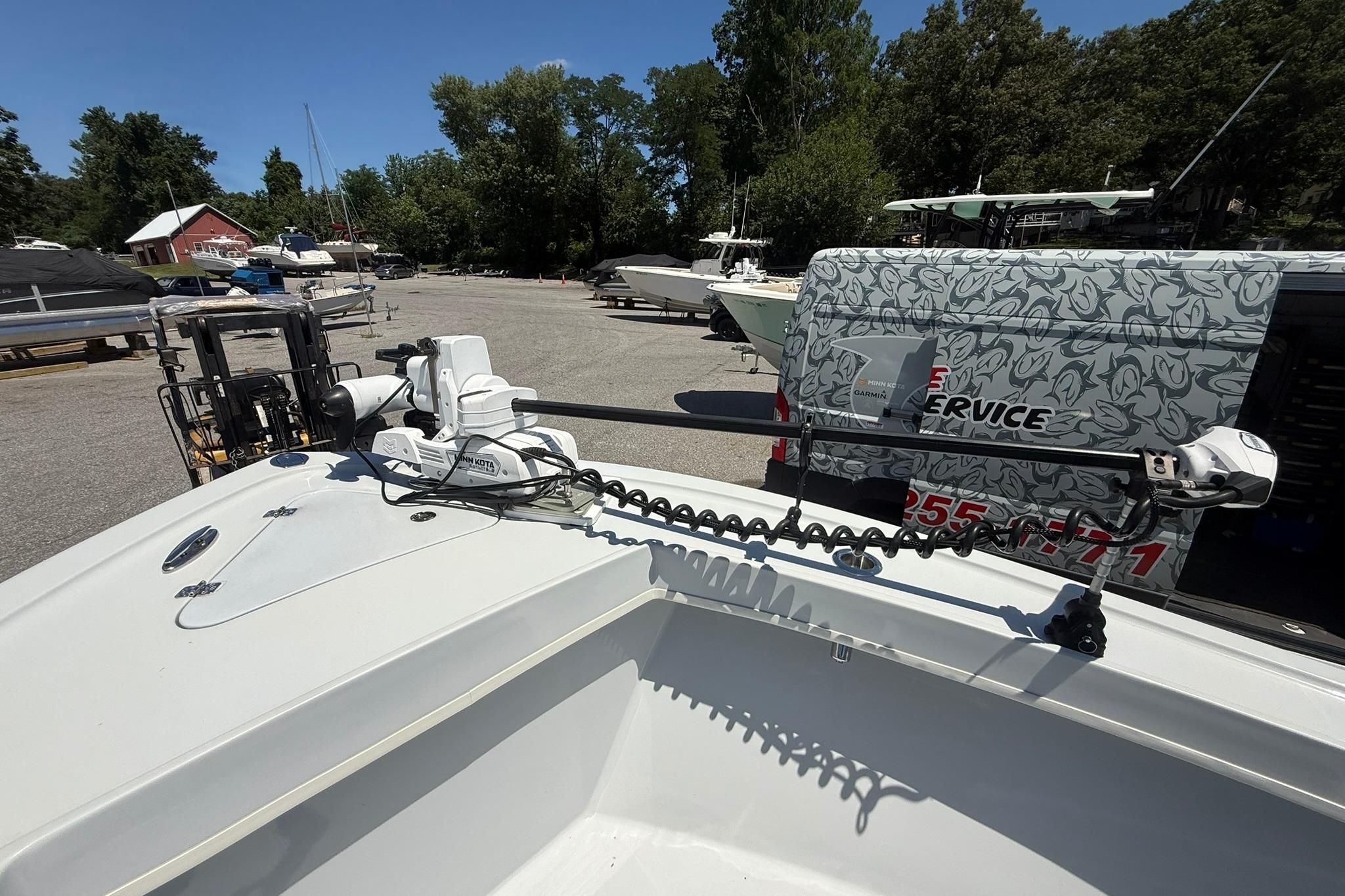 2024 Pair Customs 24 Center Console MV boat with trolling motor in a marina setting.