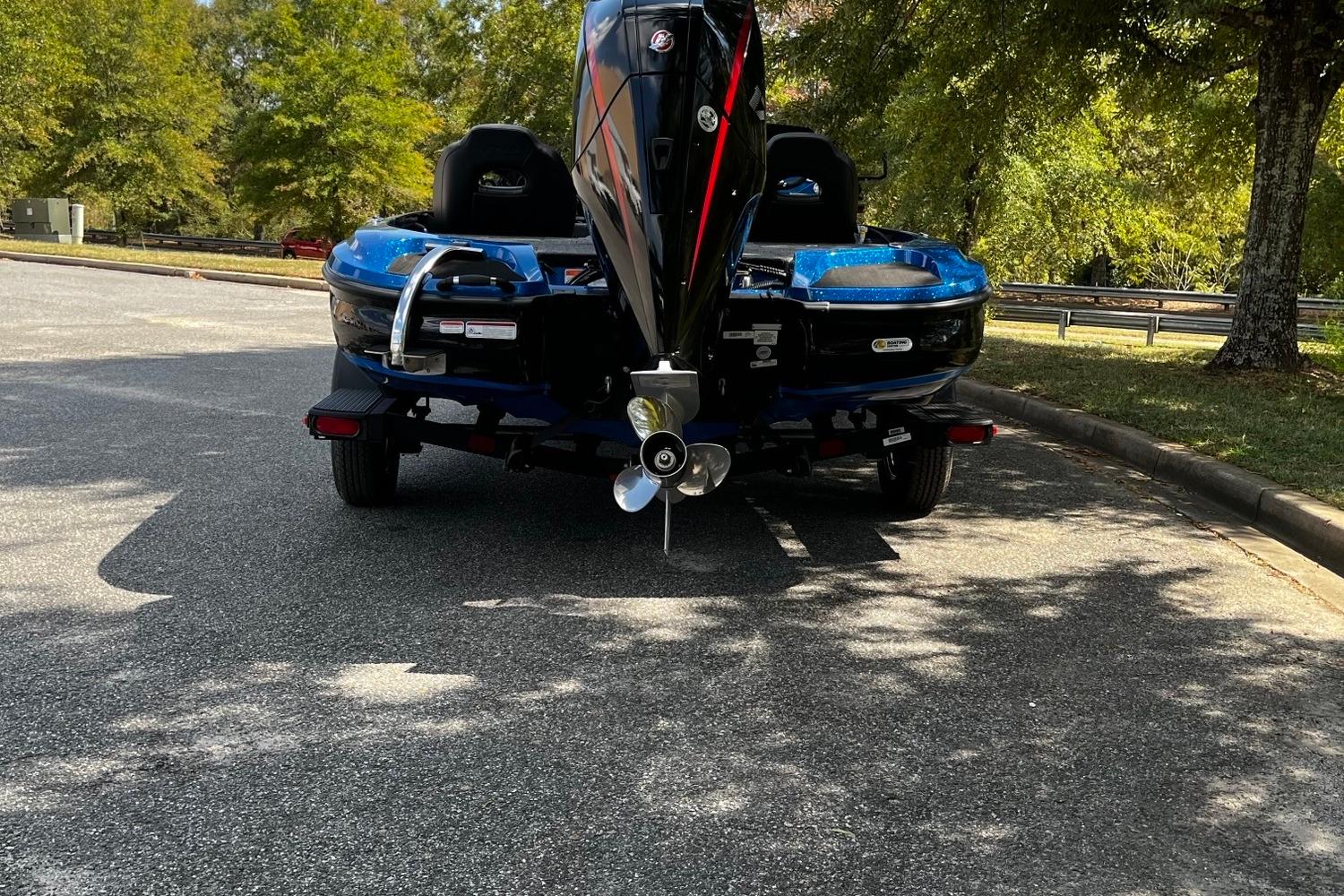 2025 Nitro Z18 boat on trailer, parked under trees in a sunny area.