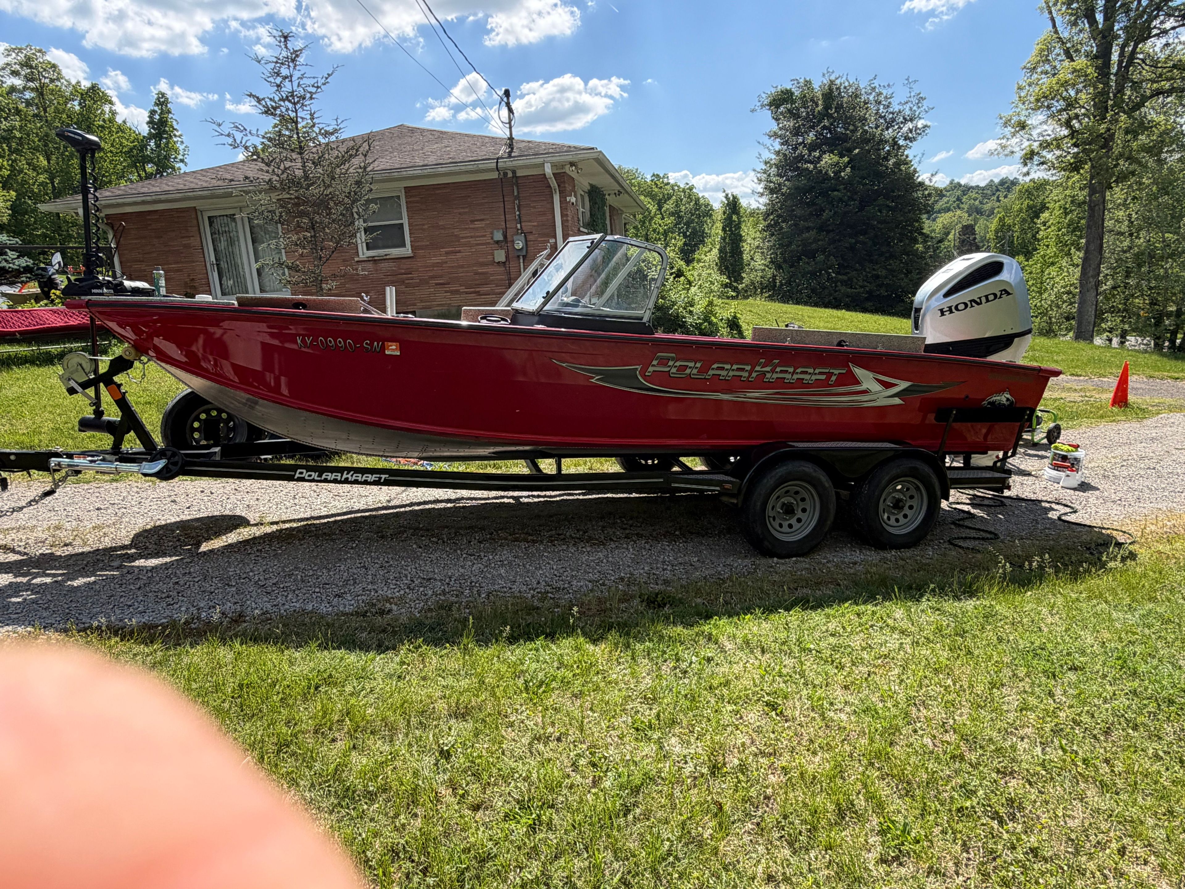 Red Polar Kraft Outlander 2010 boat on trailer, 2024 model.