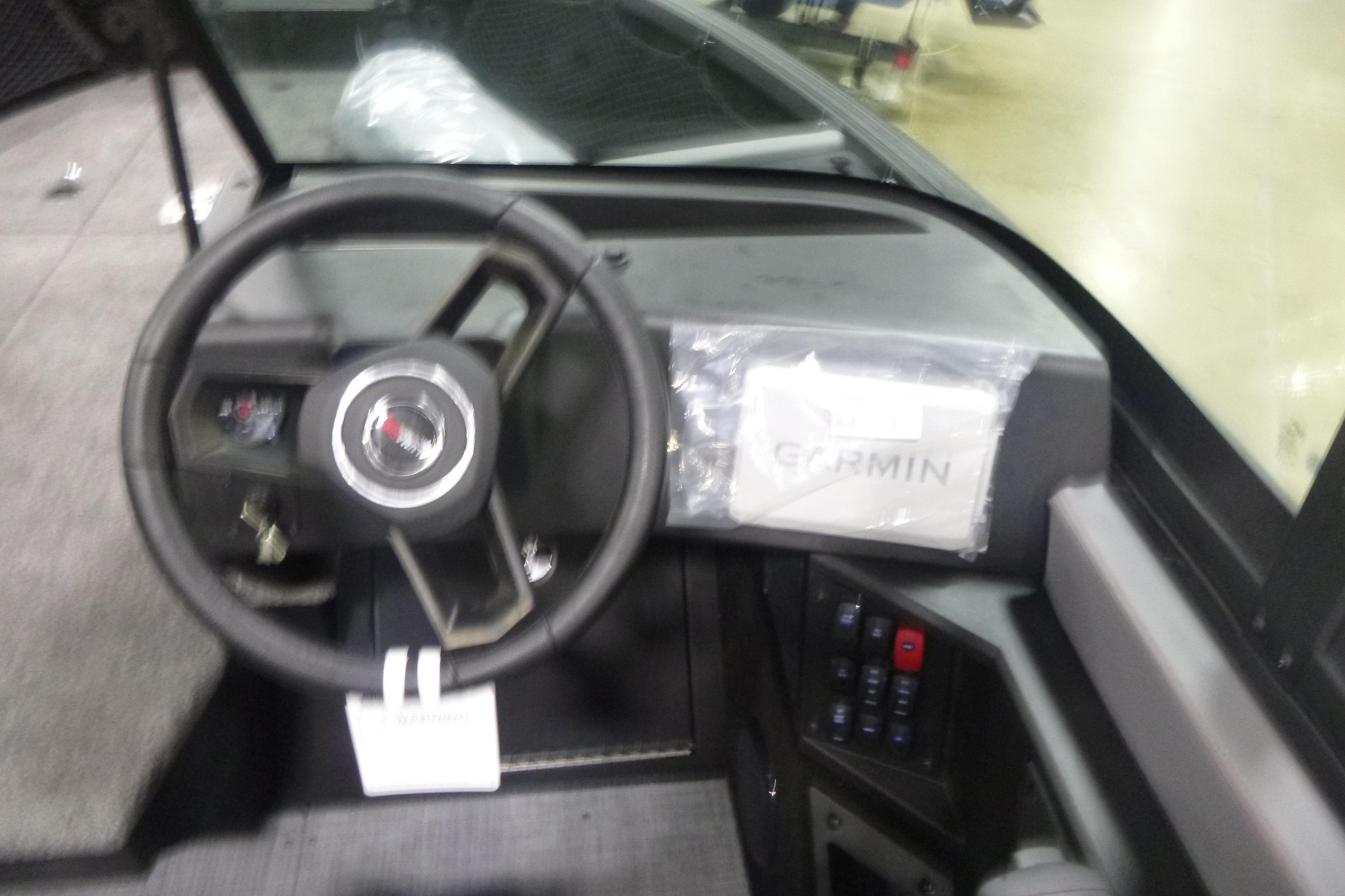 2026 Alumacraft Trophy 205X Sport boat dashboard with steering wheel and Garmin display.