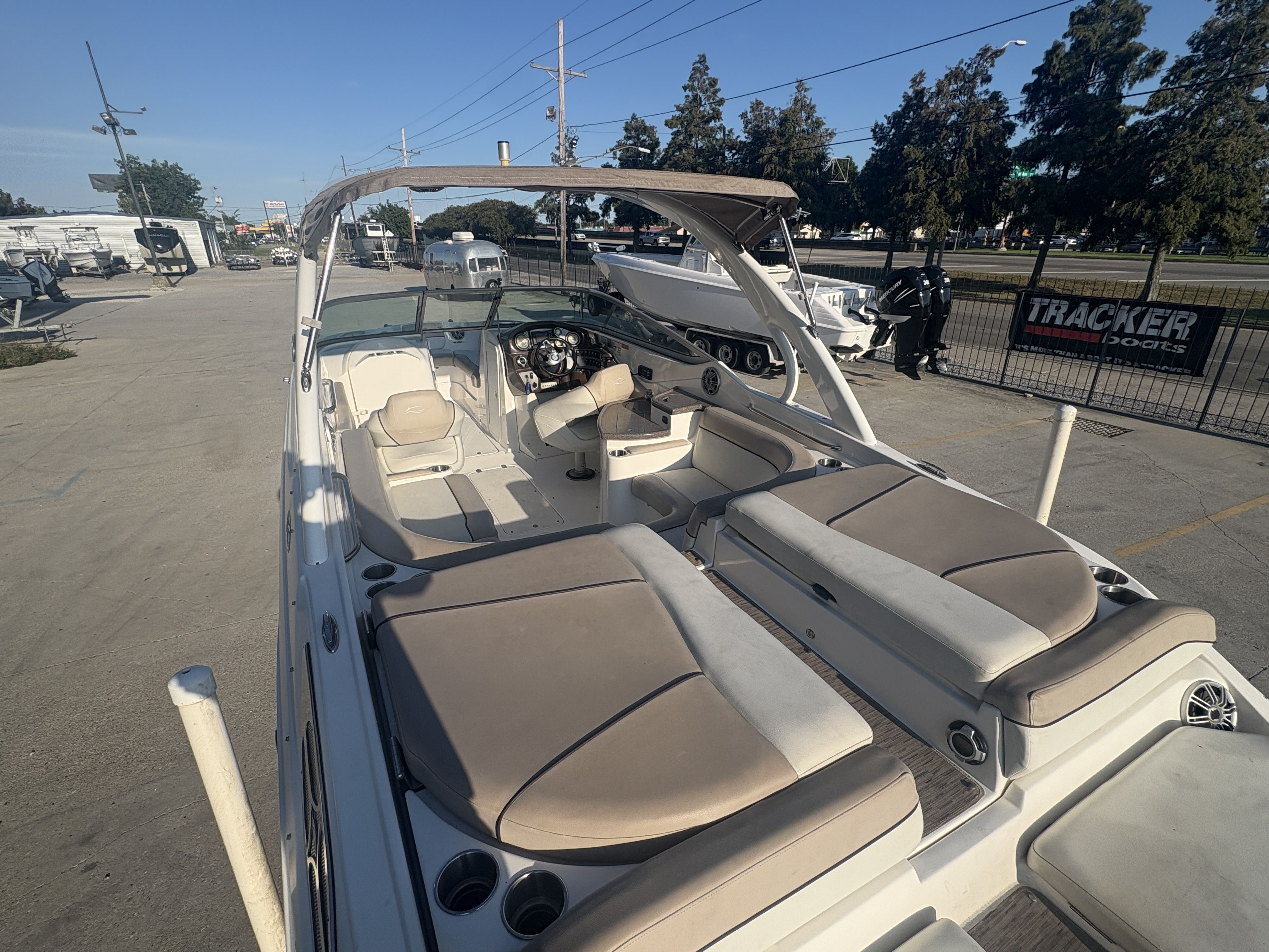 2013 Rinker Captiva 276 boat with beige seating, parked outdoors.