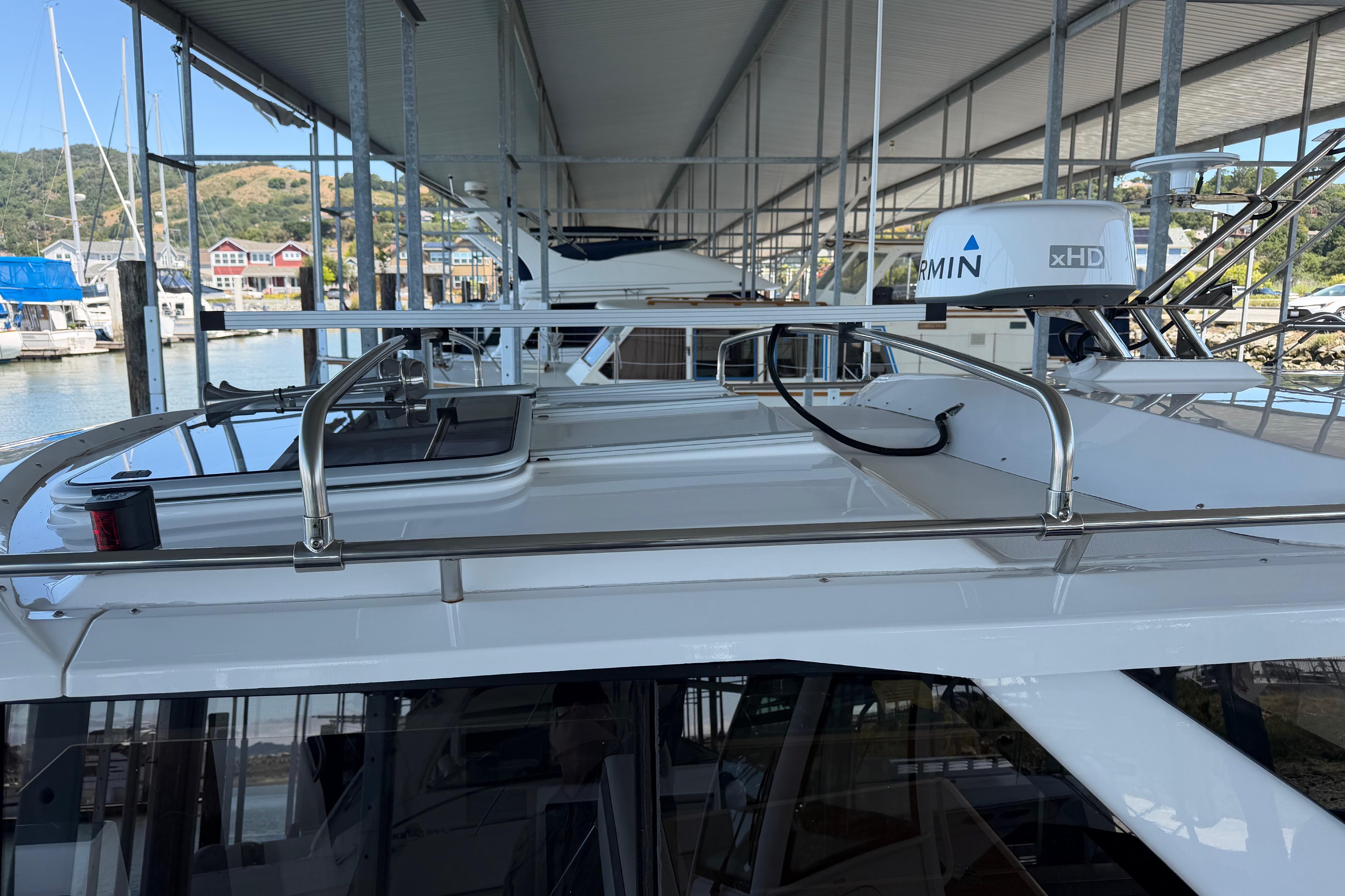 2023 Cutwater C-288 Coupe docked under a marina roof, showcasing sleek design and radar equipment.