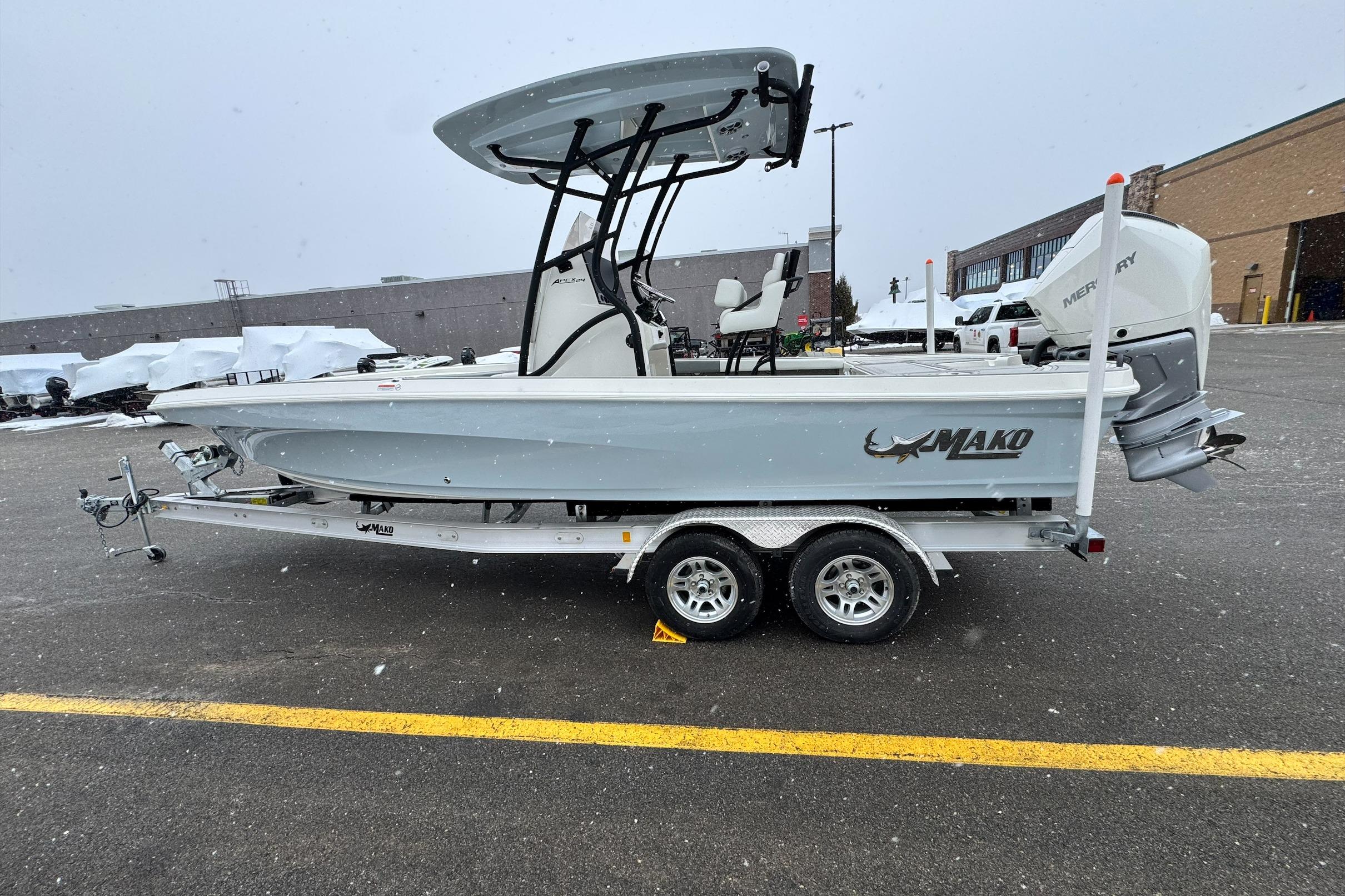 2026 Mako 24 APEX boat on trailer in snowy parking lot.