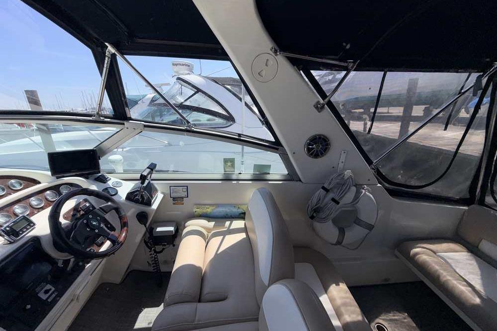 Interior view of a 2001 Monterey 282 Cruiser boat cockpit with steering wheel and seating.