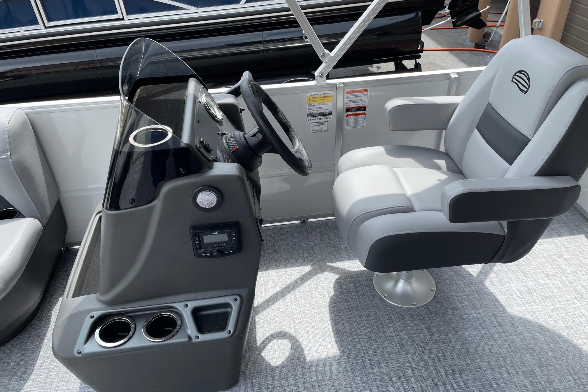 2026 Sun Tracker Party Barge 16 DLX helm with comfortable captain's chair and control panel.