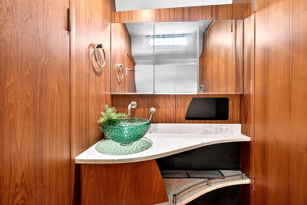 Luxurious 2006 Tiara Yachts 4300 Sovran bathroom with elegant wood paneling and modern glass sink.