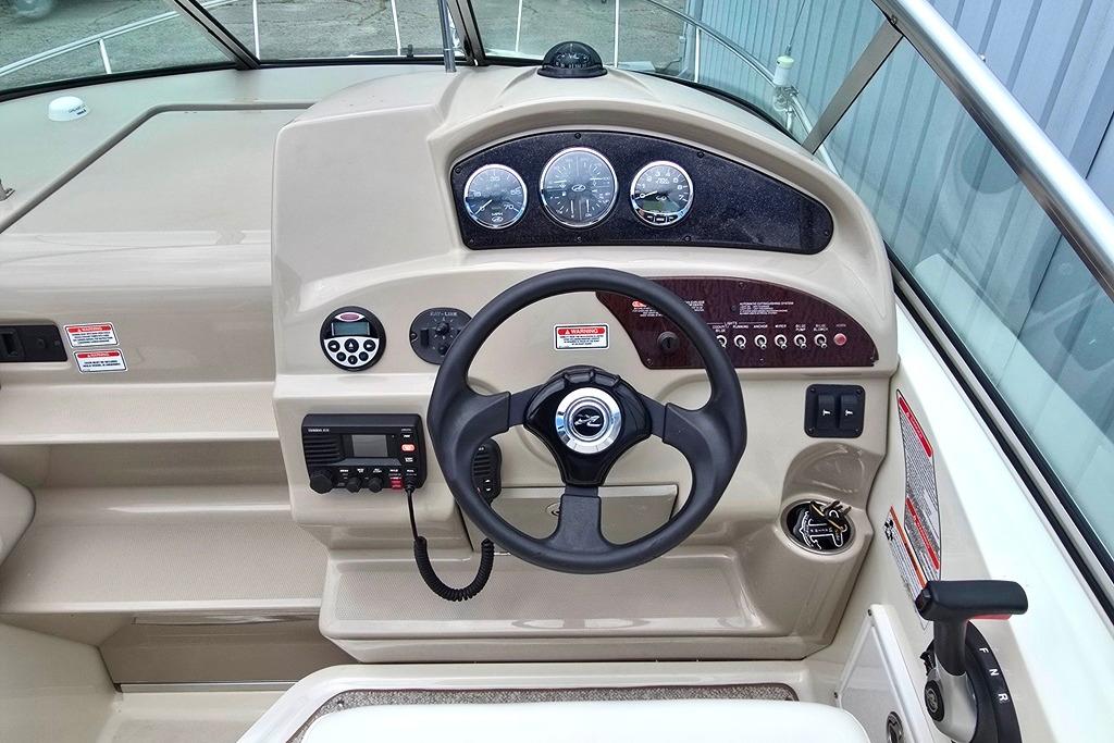 Steering console of a 2006 Sea Ray 240 Sundancer boat with gauges and controls.
