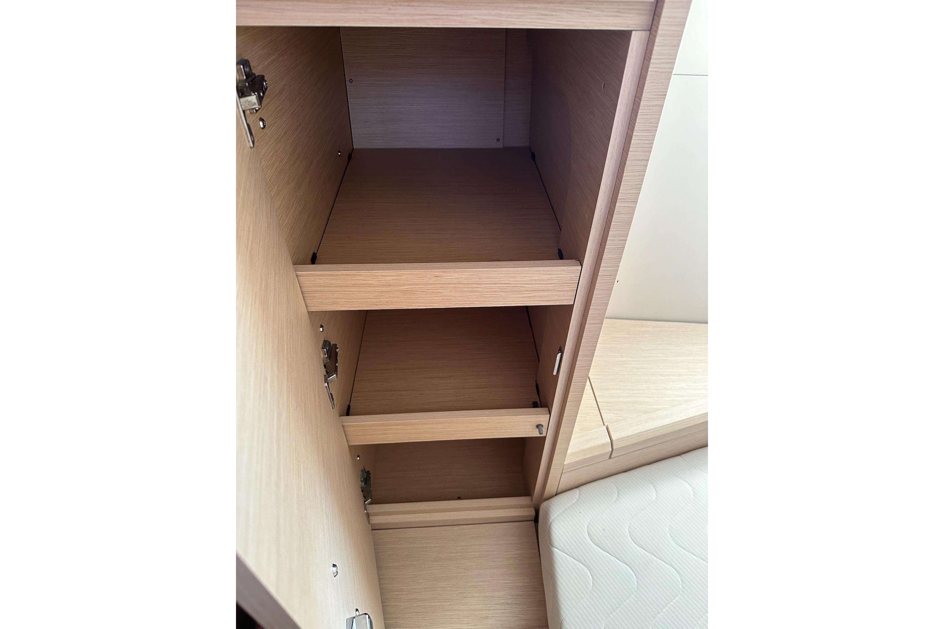 Empty wooden cabinet shelves inside a 2018 Jeanneau 51 yacht.